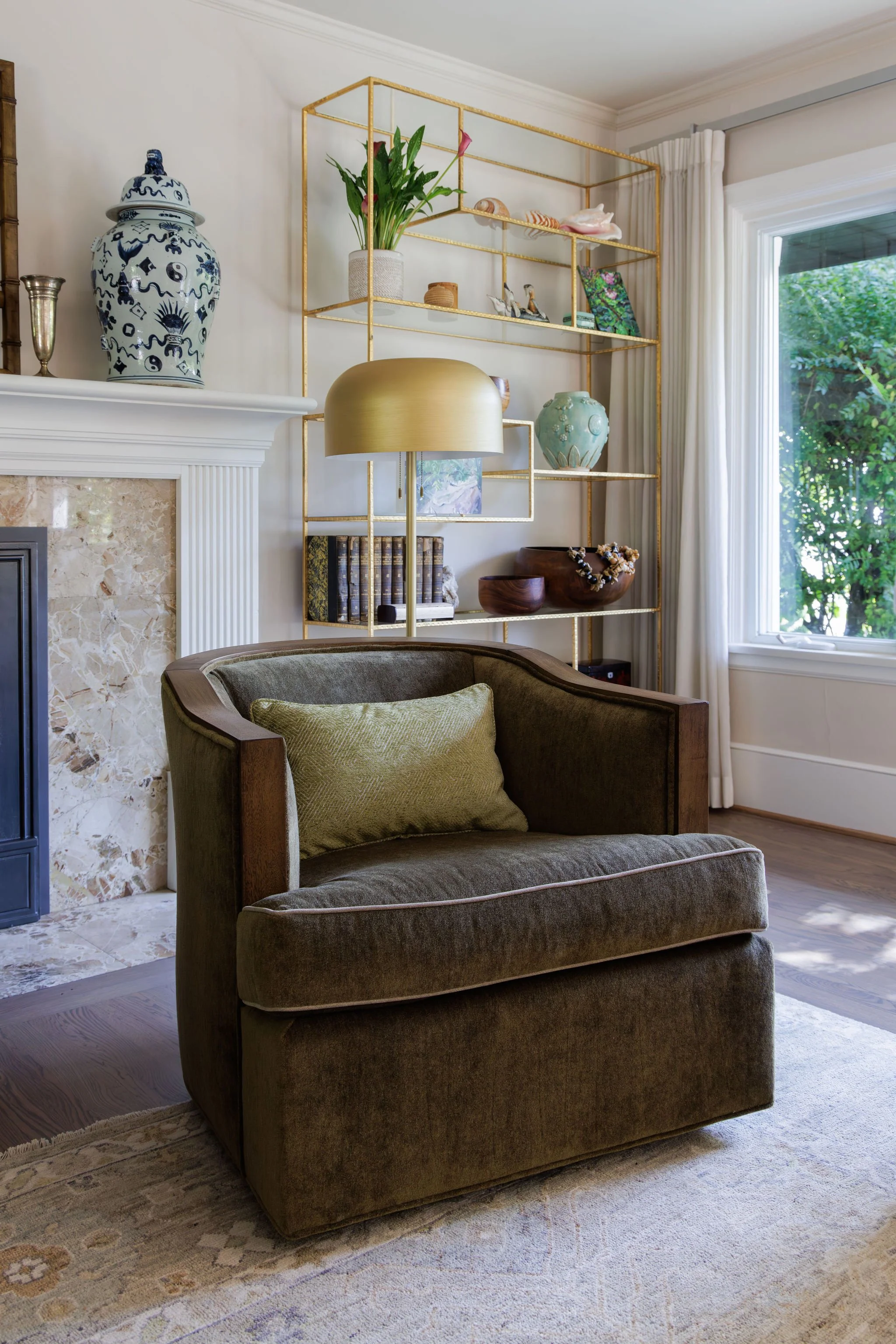 Detail of an olive green velvet armchair and gold dome floor lamp by Full Bloom Interior Design in Seattle.