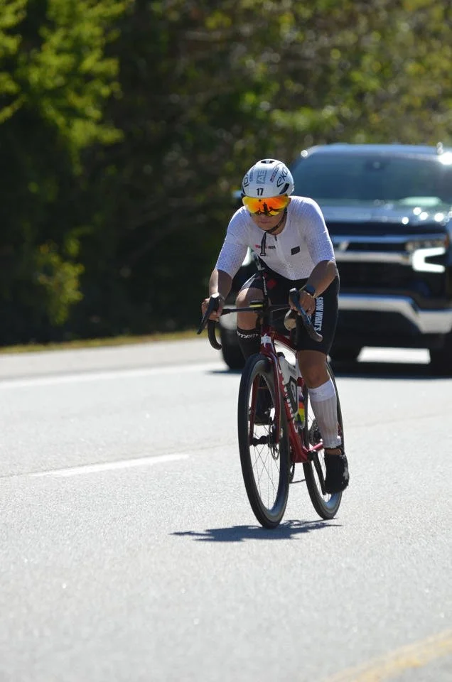 Robert Norris Man of Iron cycling on a tree-lined road during Ironman Chattanooga