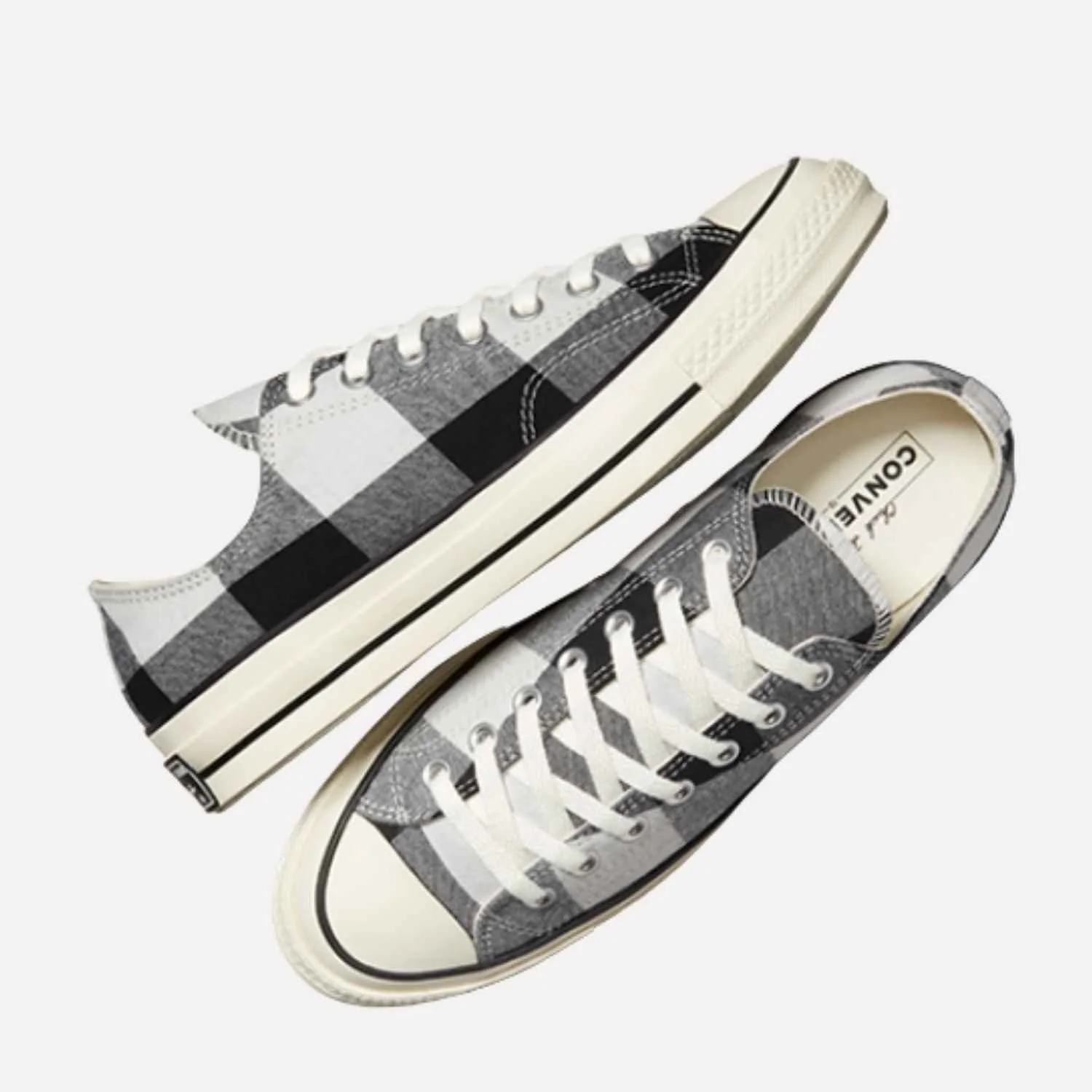 Gray and white checkered Converse sneakers with white laces on a white background featuring upcycled components manufactured by Beyond Remade.