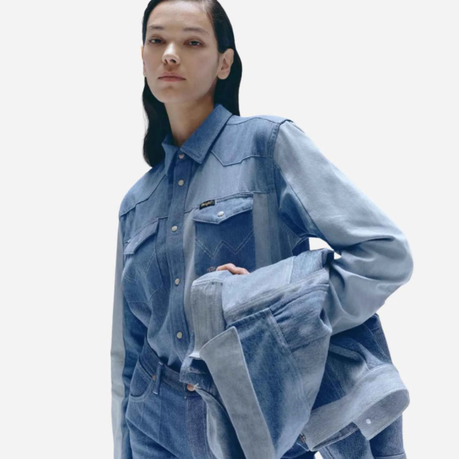 A person wears an upcycled denim jacket and jeans manufactured by Beyond Remade for the global fashion brand Wrangler.