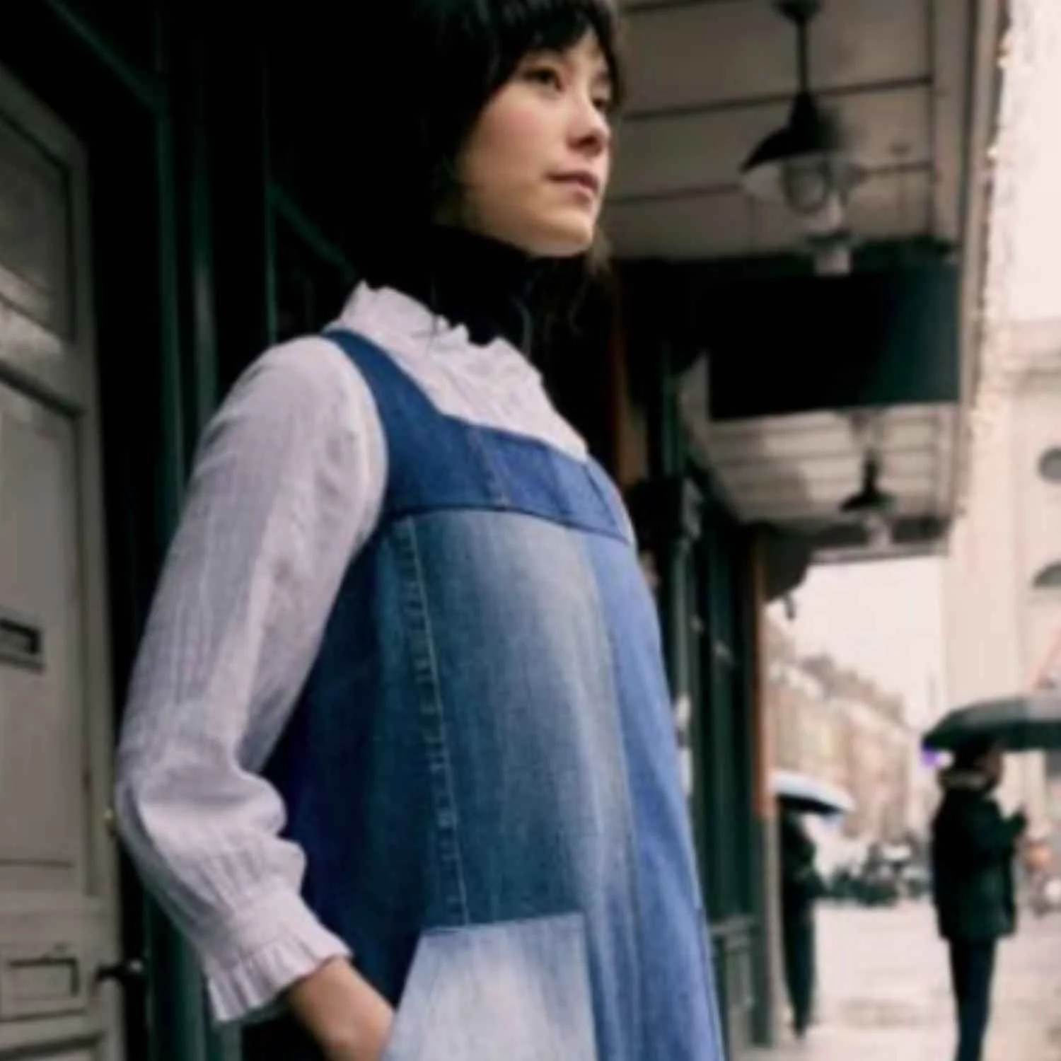 A woman wearing an upcycled denim dress manufactured by Beyond Remade for the British fashion brand Sea Salt Cornwall.