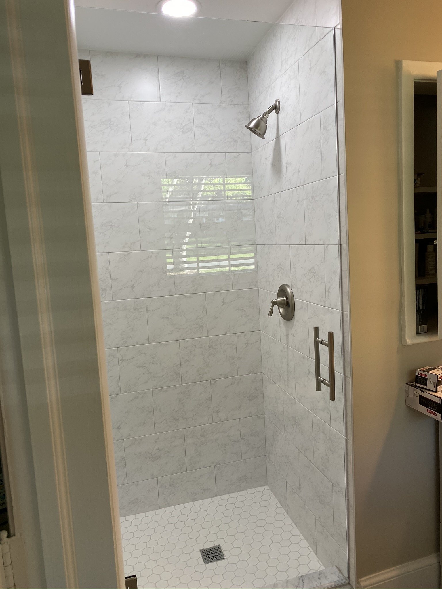 01-finished-shower-marble-look-wall-and-hex-floor-tile.jpeg