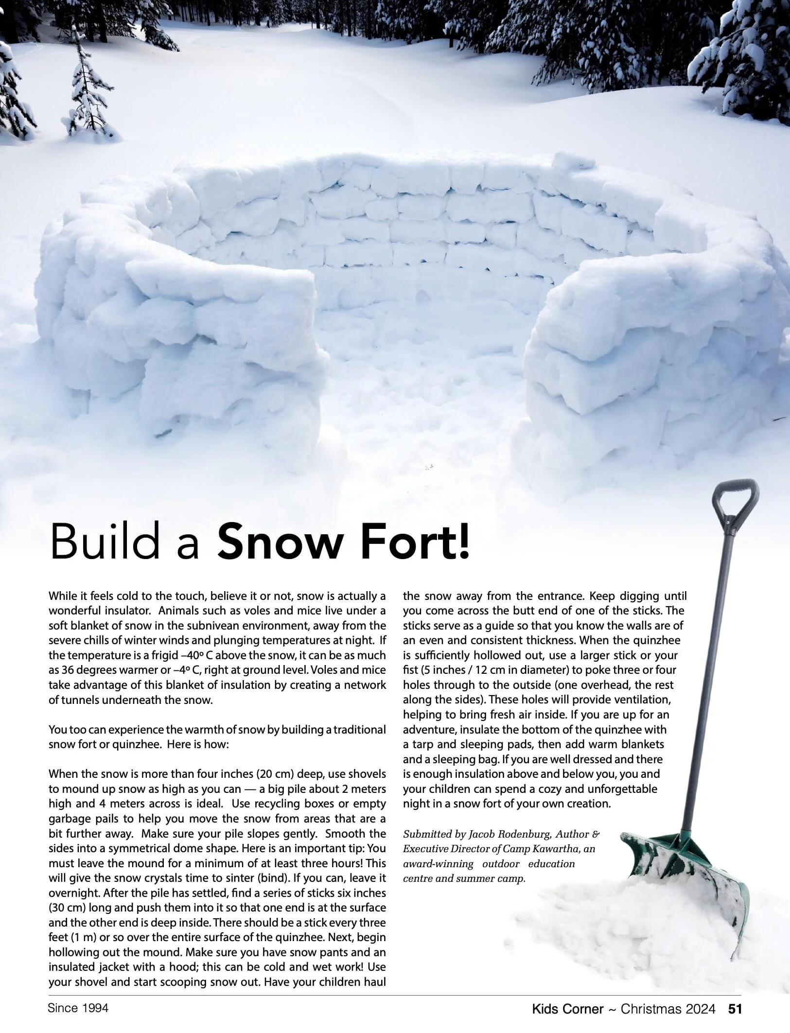 A snowy landscape with snow-covered trees in the background. In the foreground, there is a partially built snow fort or structure made from snow blocks. To the right, a snow shovel is partially visible. The image appears to be part of a magazine or article page about building a snow fort, with text below the image explaining how to build one.