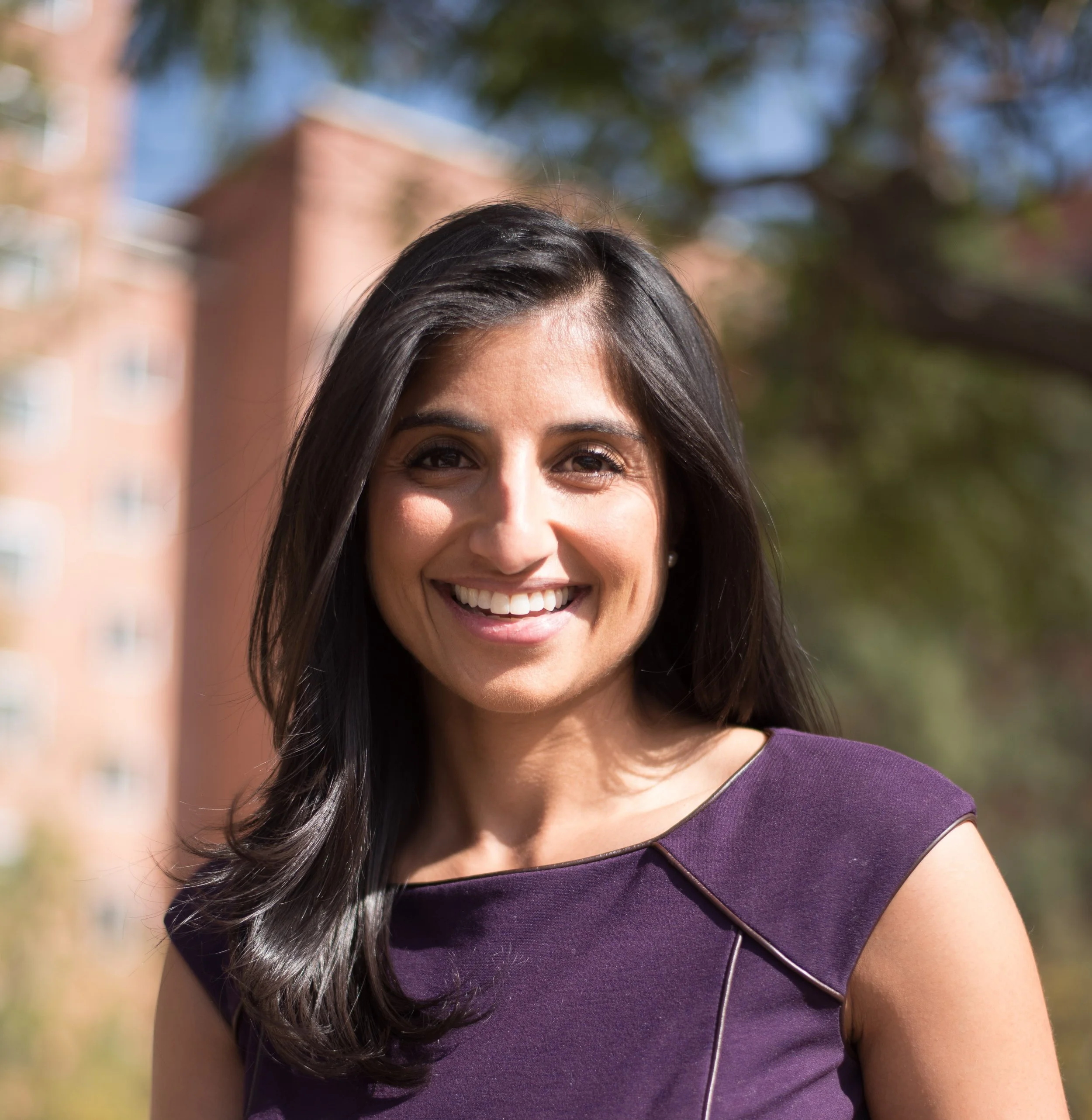 Headshot of woman on sunny day, smiling at camera