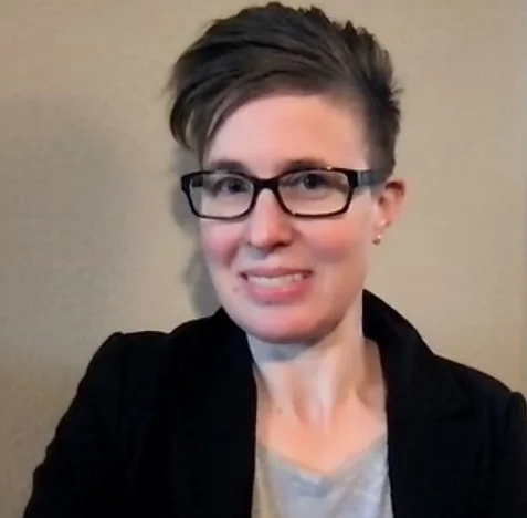 Headshot of woman in blazer smiling at camera