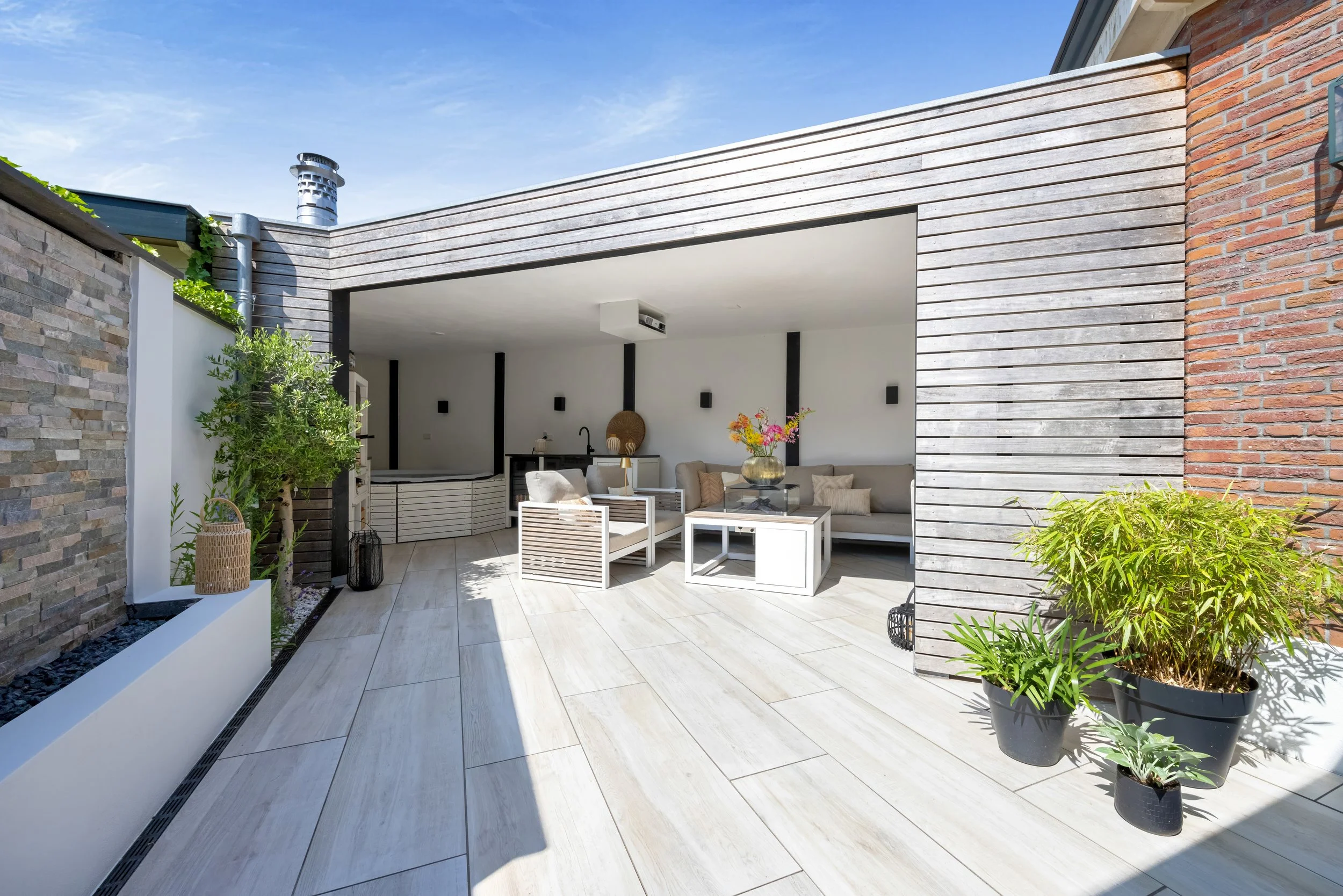 Moderne terras met zithoek en planten, overdekt deel van een buitenruimte op een dakterras of patio.