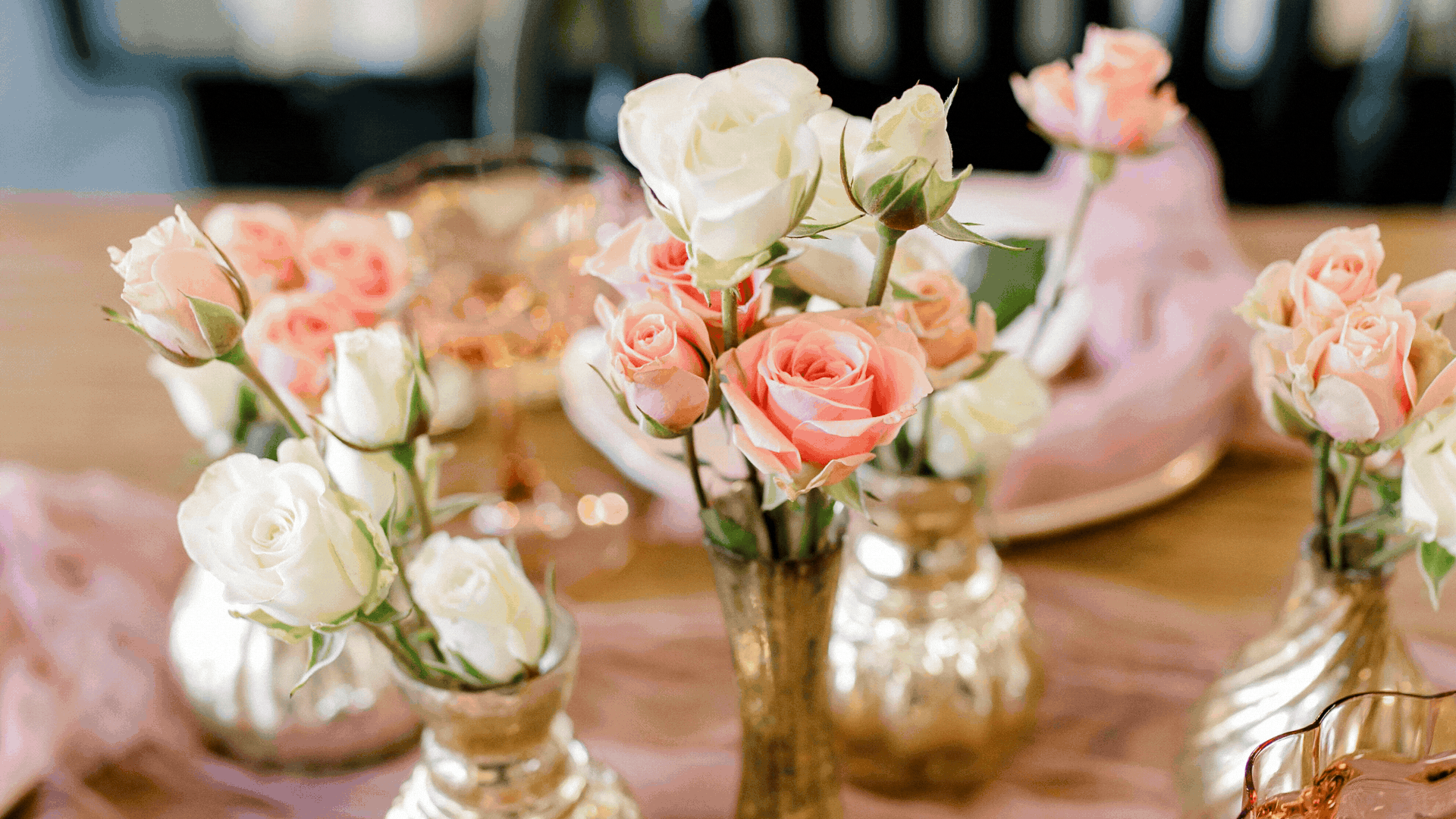 Vase with pink and white roses on a table, decorated for a special occasion.