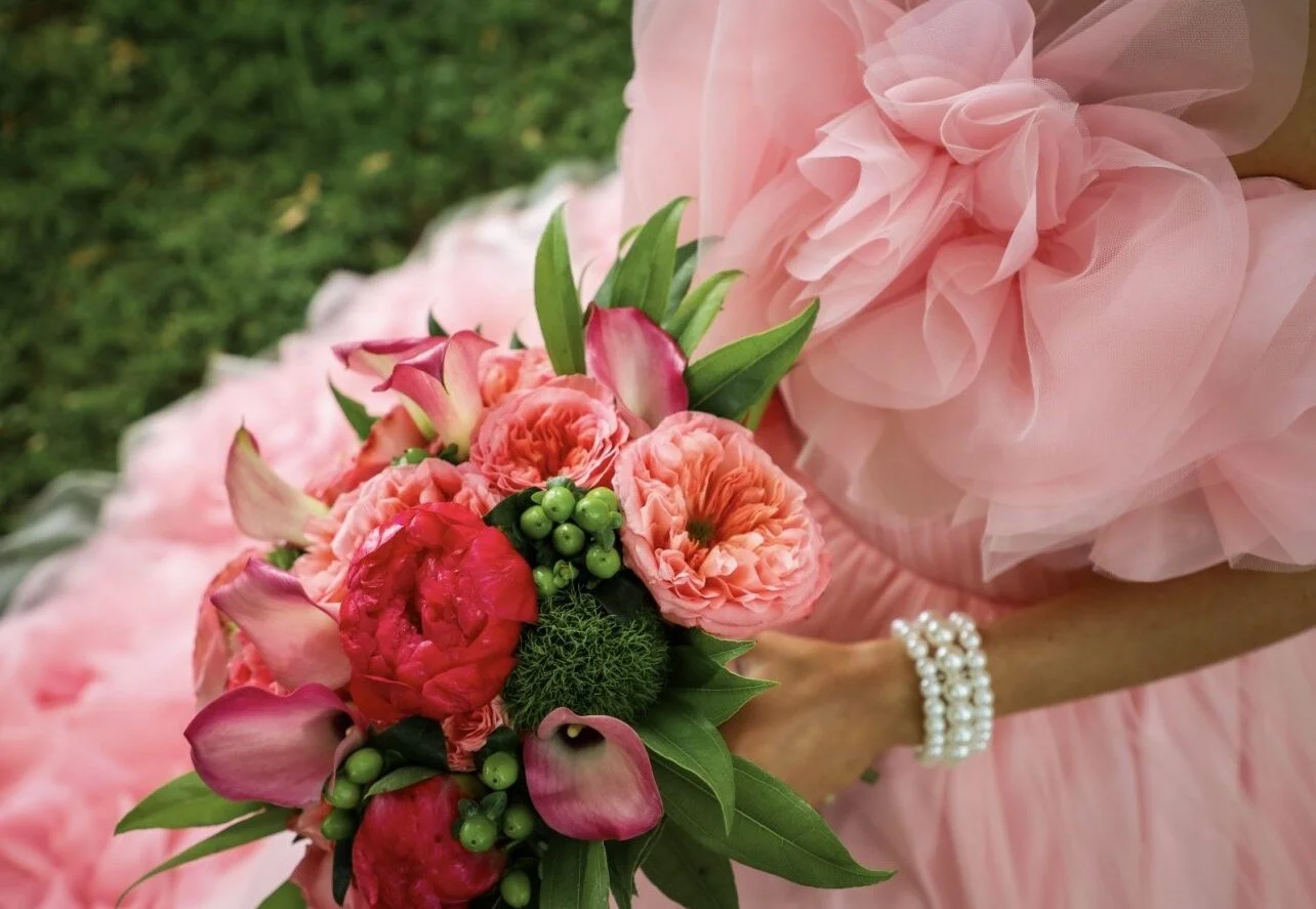 Hand tied bouqut of pink garden roses and callas with magenta peonies.
