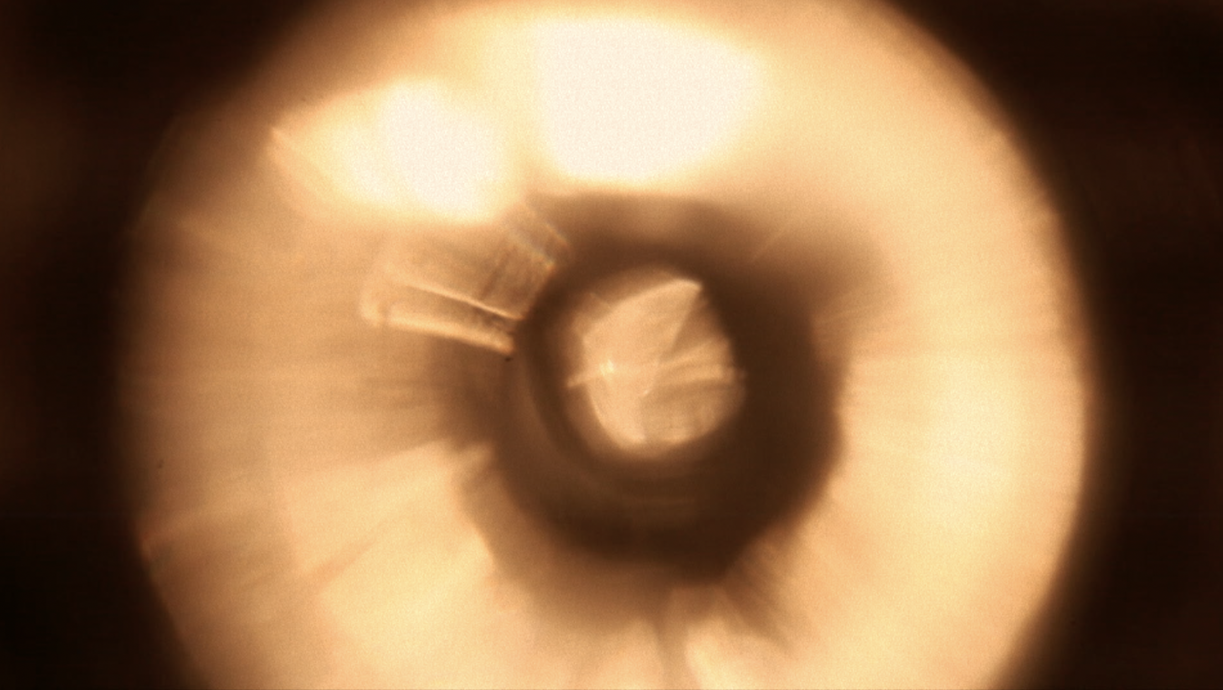 Une vue en gros plan d'une spirale dorée, semblant être un objet métallique ou une pièce mécanique, avec un effet de flou