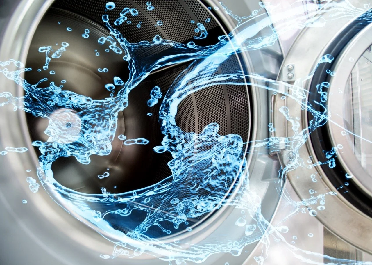 A front-loading washing machine with water splashing inside, depicted with digital blue water effects.