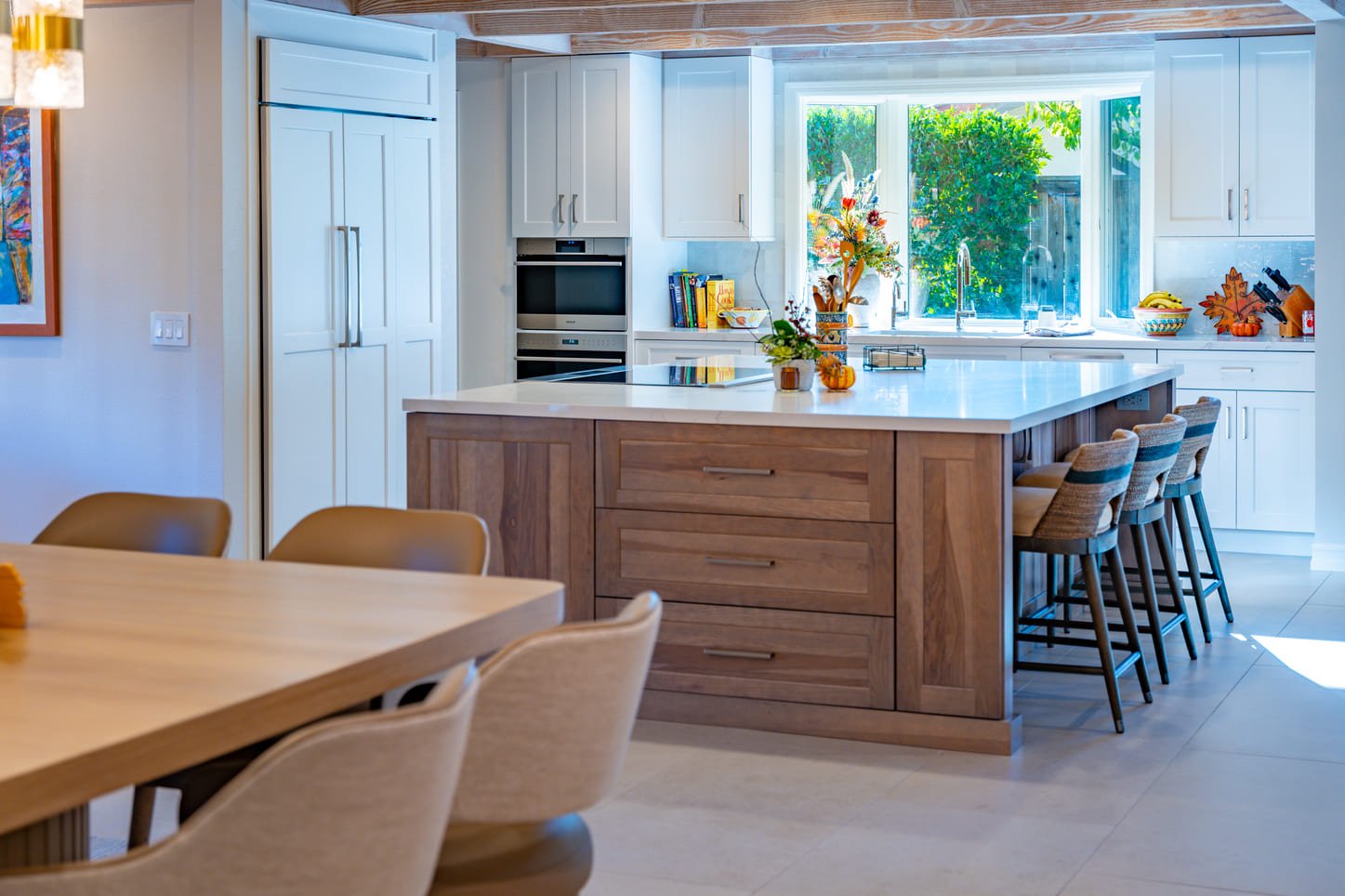 Bright custom kitchen interior designed by NM Designs featuring curated construction finish selections, warm wood cabinetry, white quartz countertops, layered textures, natural light, and thoughfully selected materials for timeless Orange County