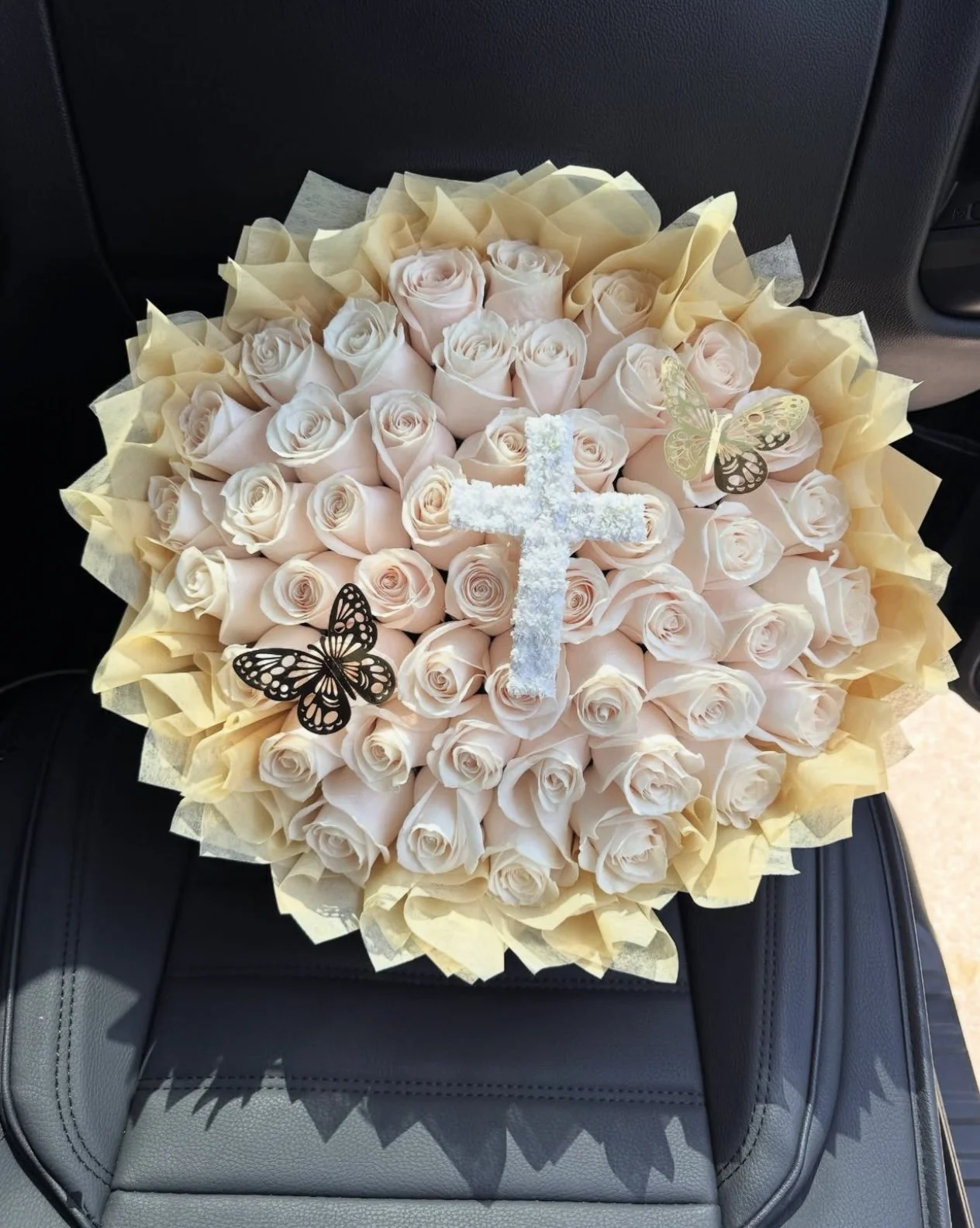 50 White roses, cotton filler, butterflies, and floral cross.