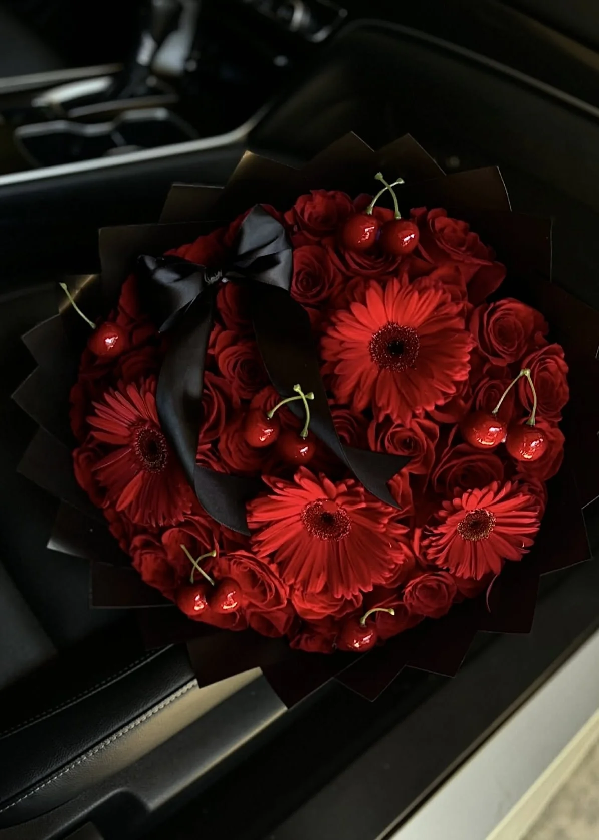 50 red roses, red gerberas, cherries, and a bow