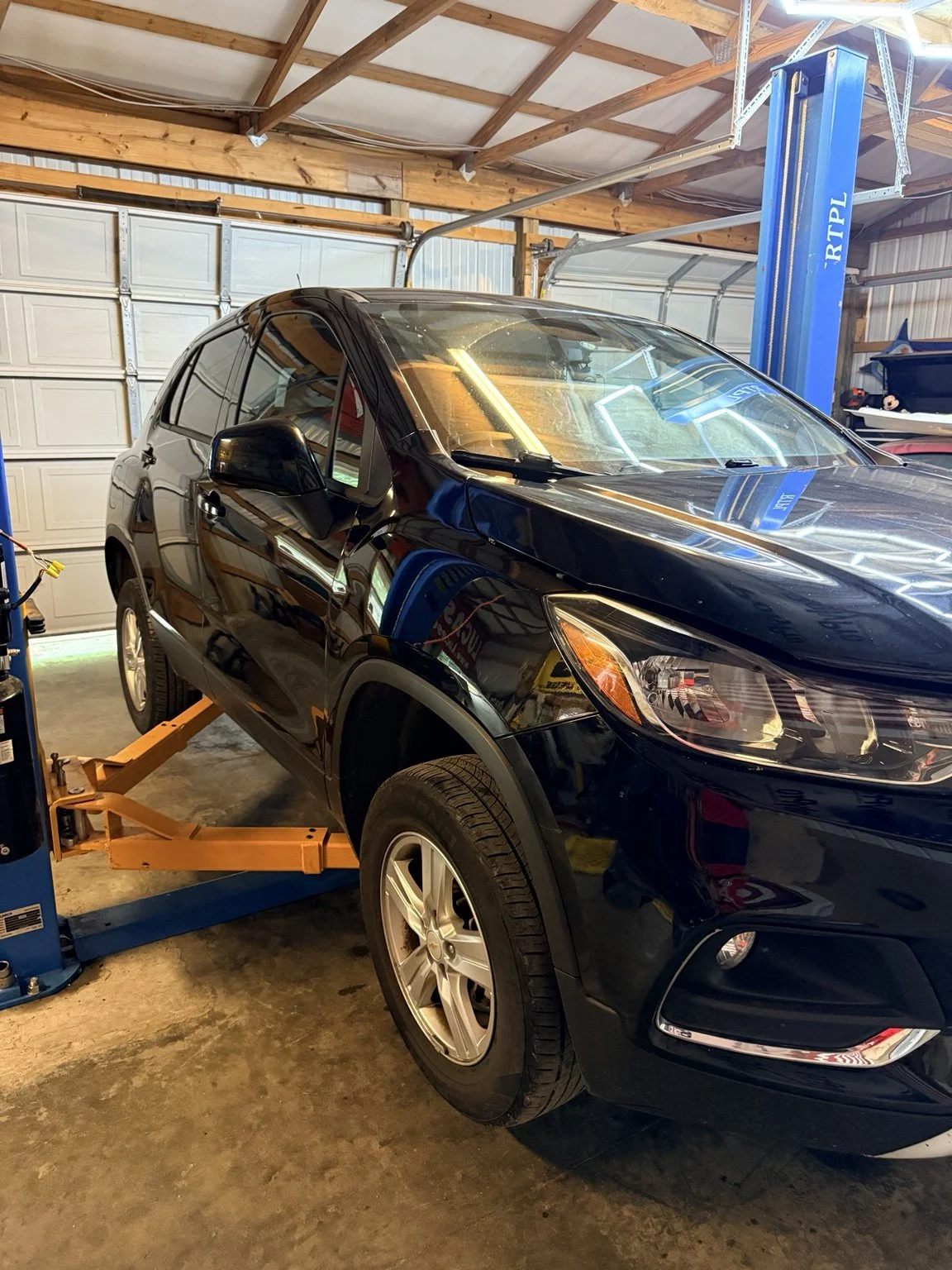 Black SUV positioned on a vehicle lift inside WARHORSE Garage in Utica, Kentucky.