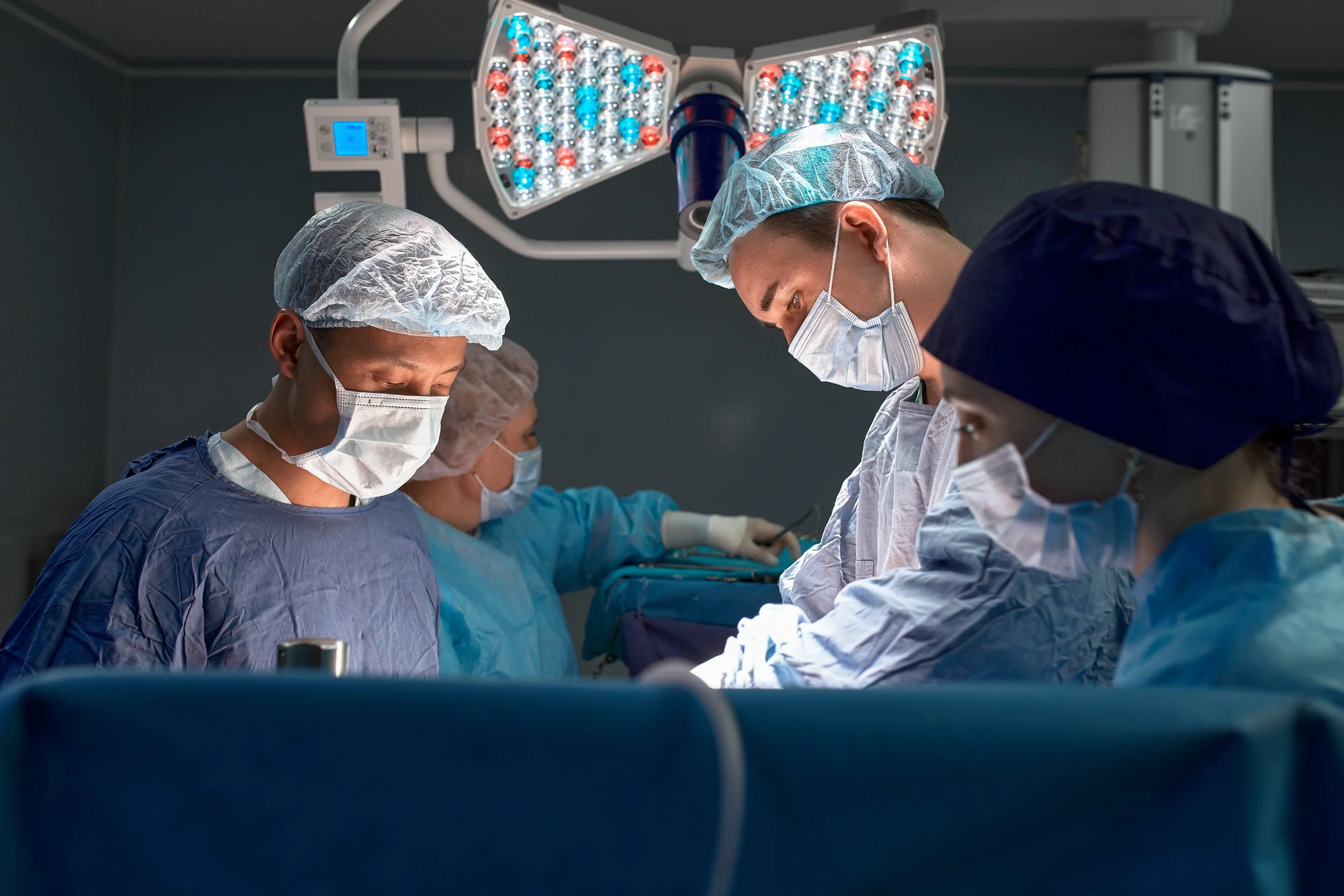 portrait of surgeons leaned over patient