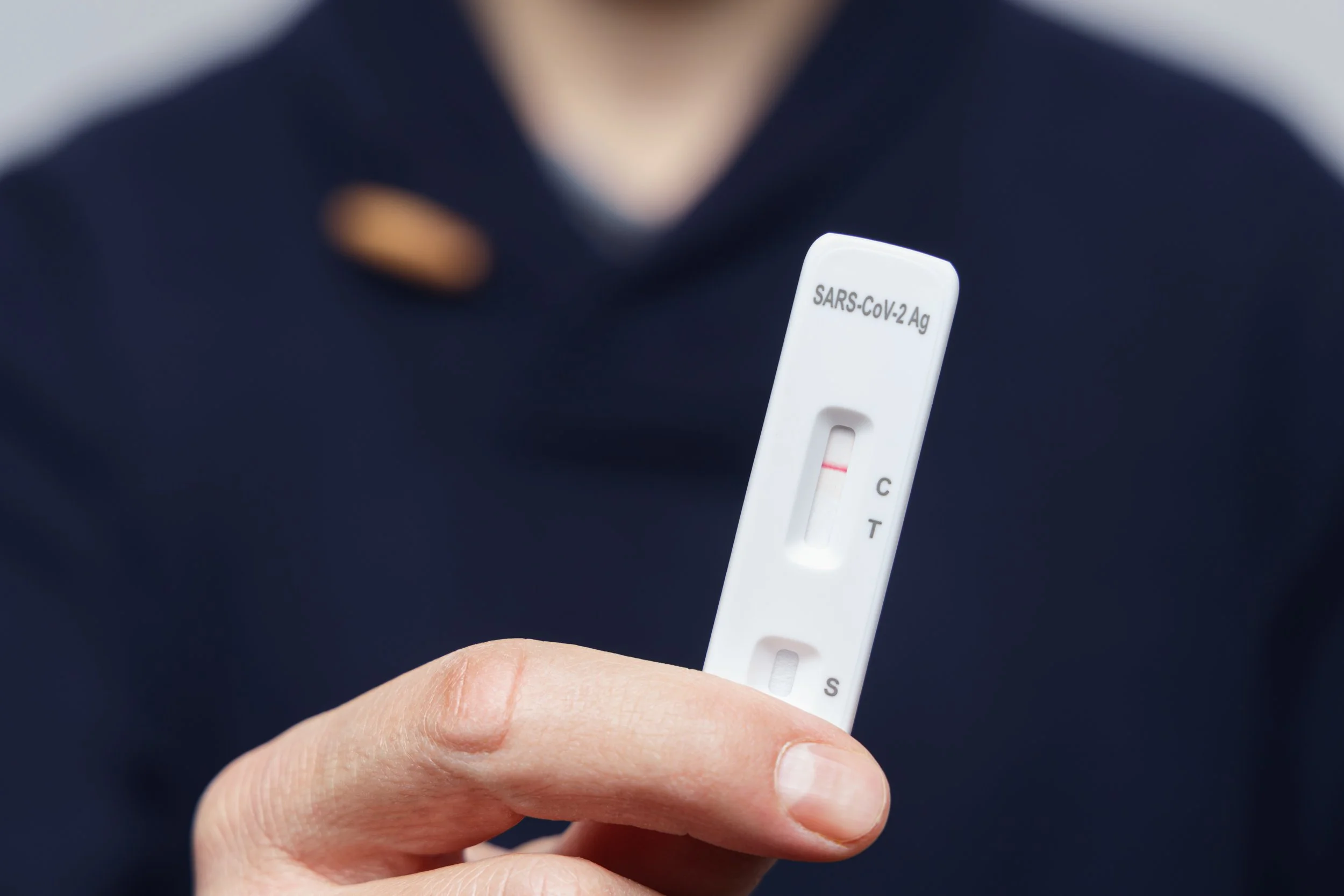 hand holding a negative covid antigen rapid test