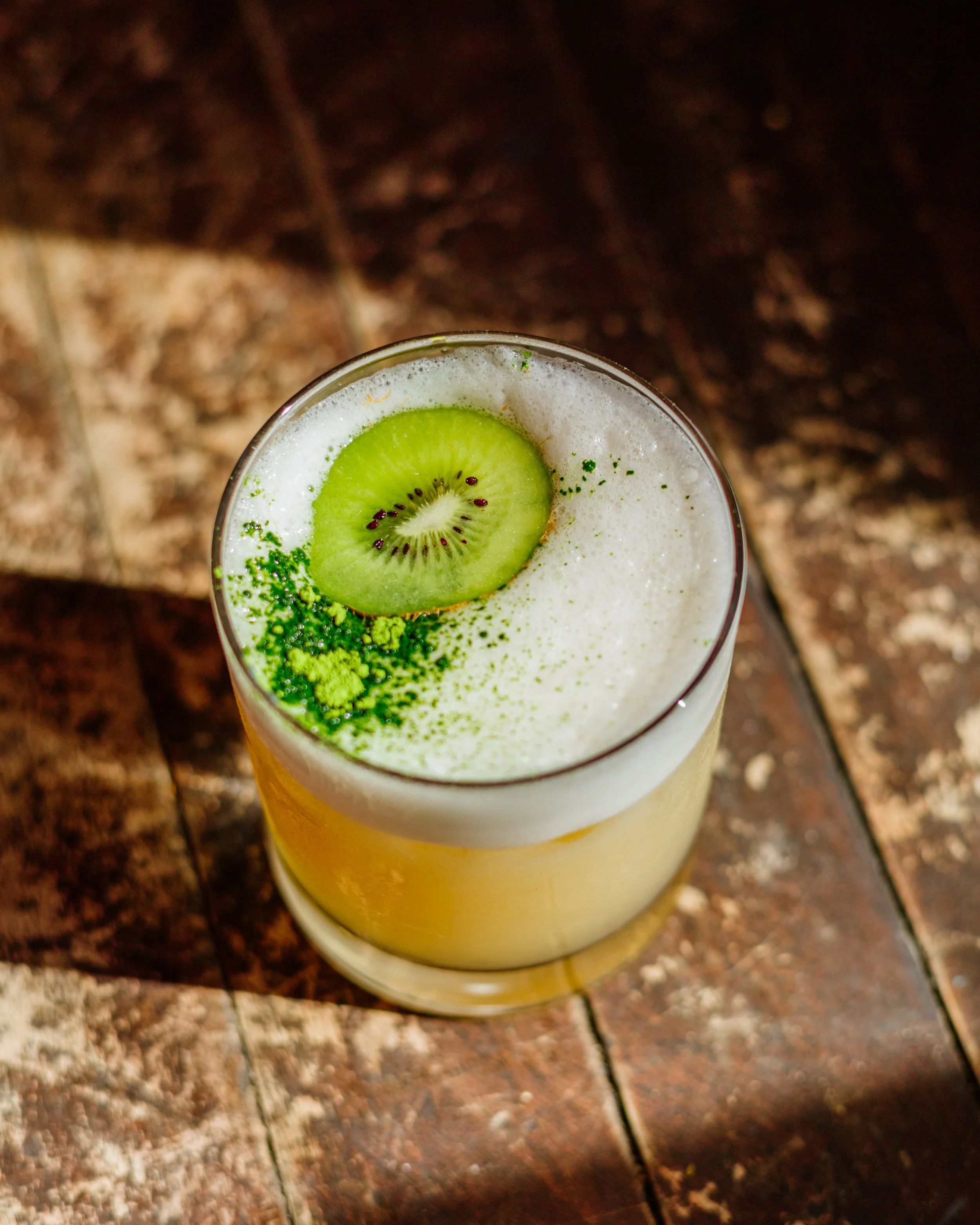 Verre de smoothie santé garni de tranches de kiwi et de poudre de matcha