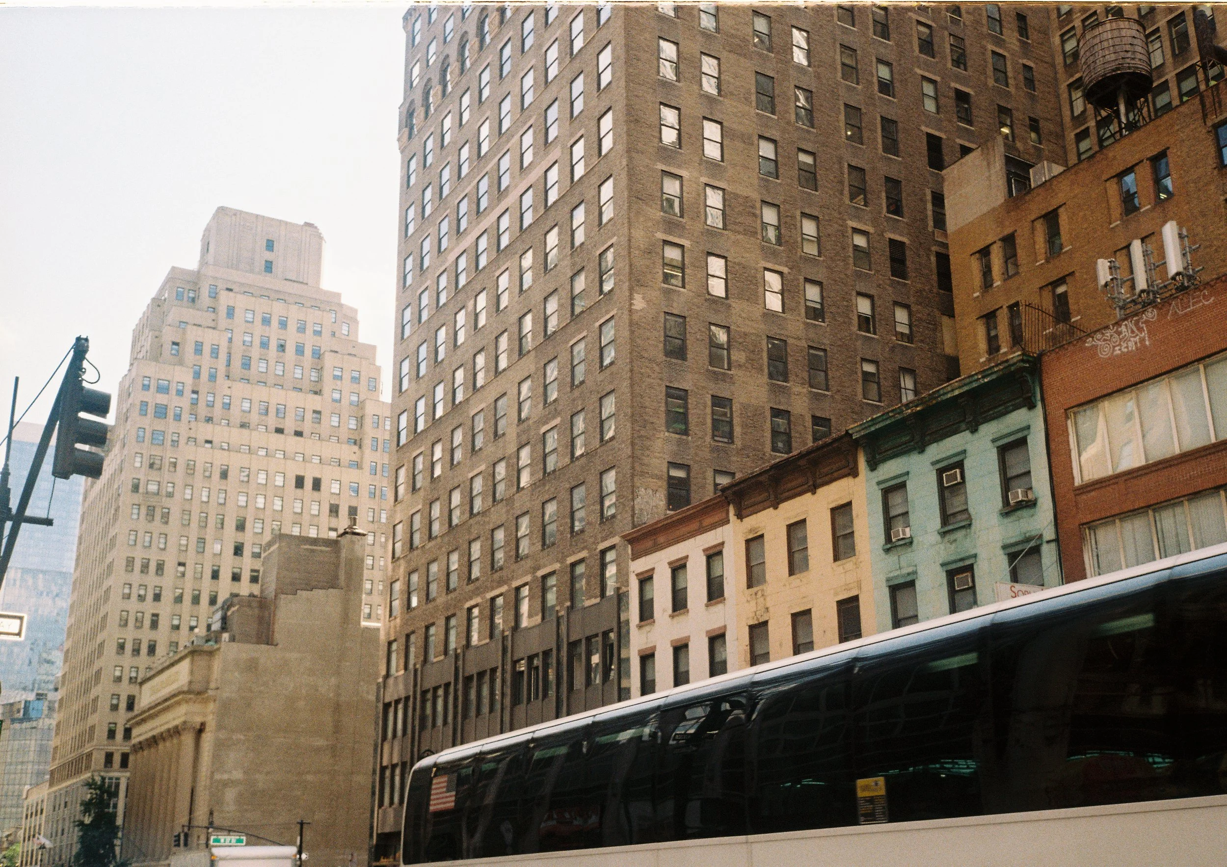 Street view of large and small city buildings plus bus