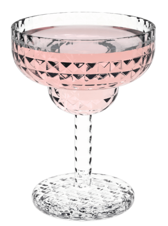 A clear, cut-glass cocktail glass with a pink liquid inside.