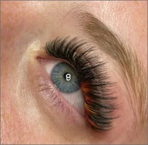 Close-up of a human eye with long, thick eyelashes.