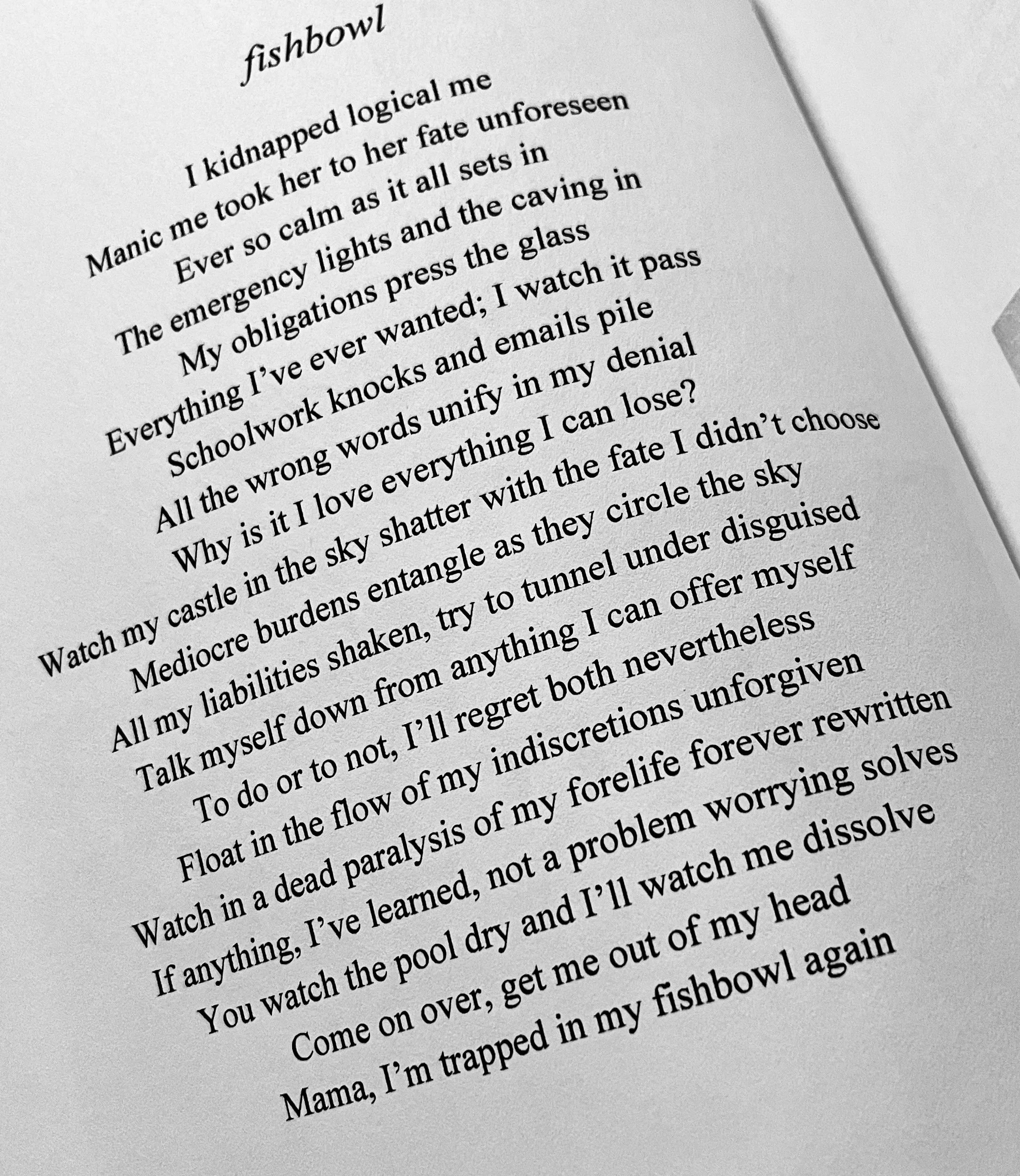 A printed poem titled 'fishbowl' with a series of poetic lines about personal struggles and emotional reflection.