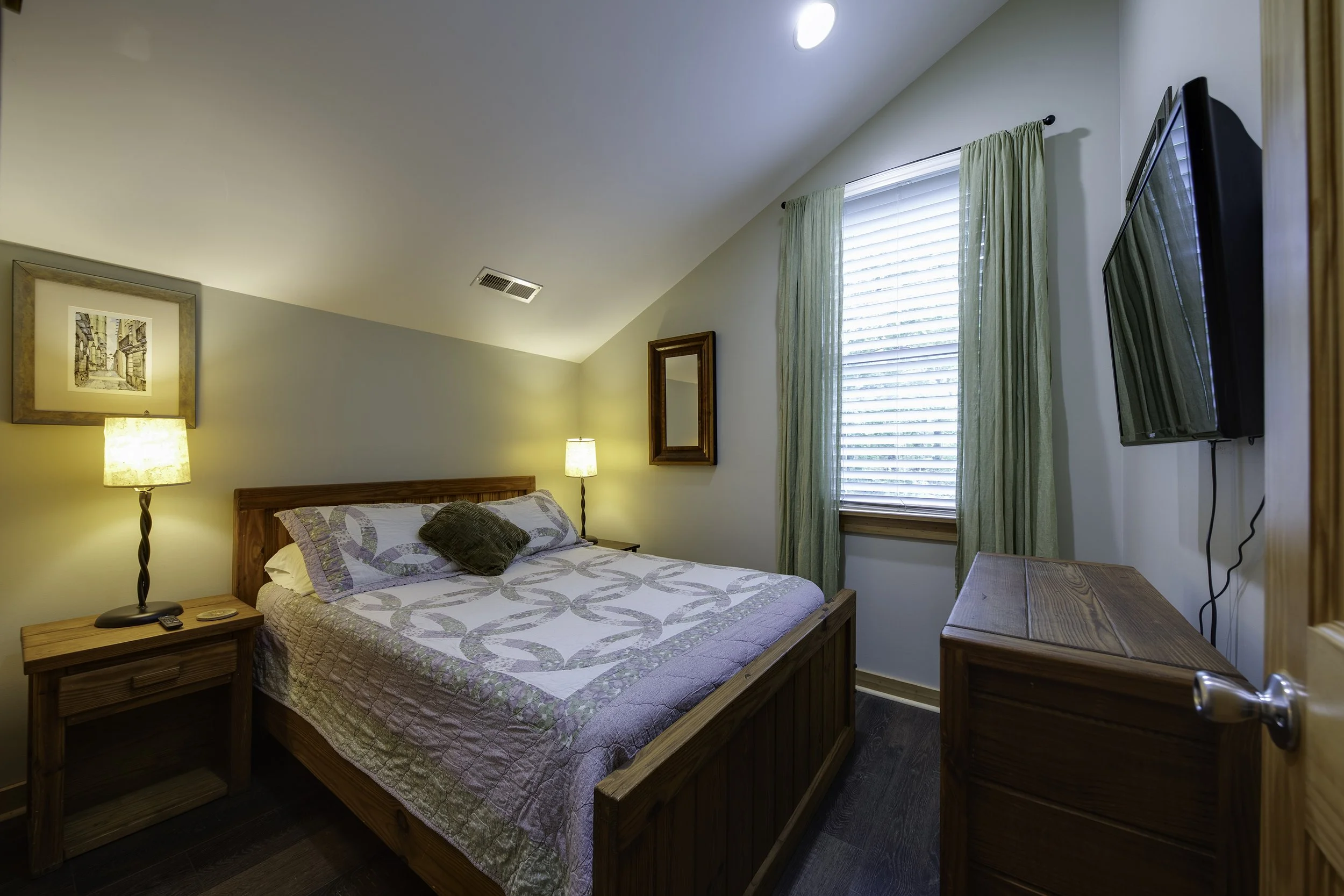 Second bedroom with full sized bed and TV. Closet is to the left of the bed.