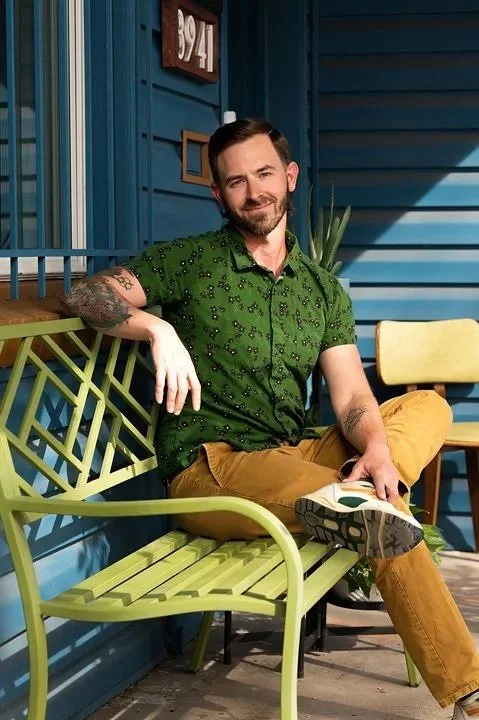 Portrait of Licensed Professional Counselor, Adam Stanford, posing in Colorado. He wears a green shirt and mustard-colored pants, and white sneakers.