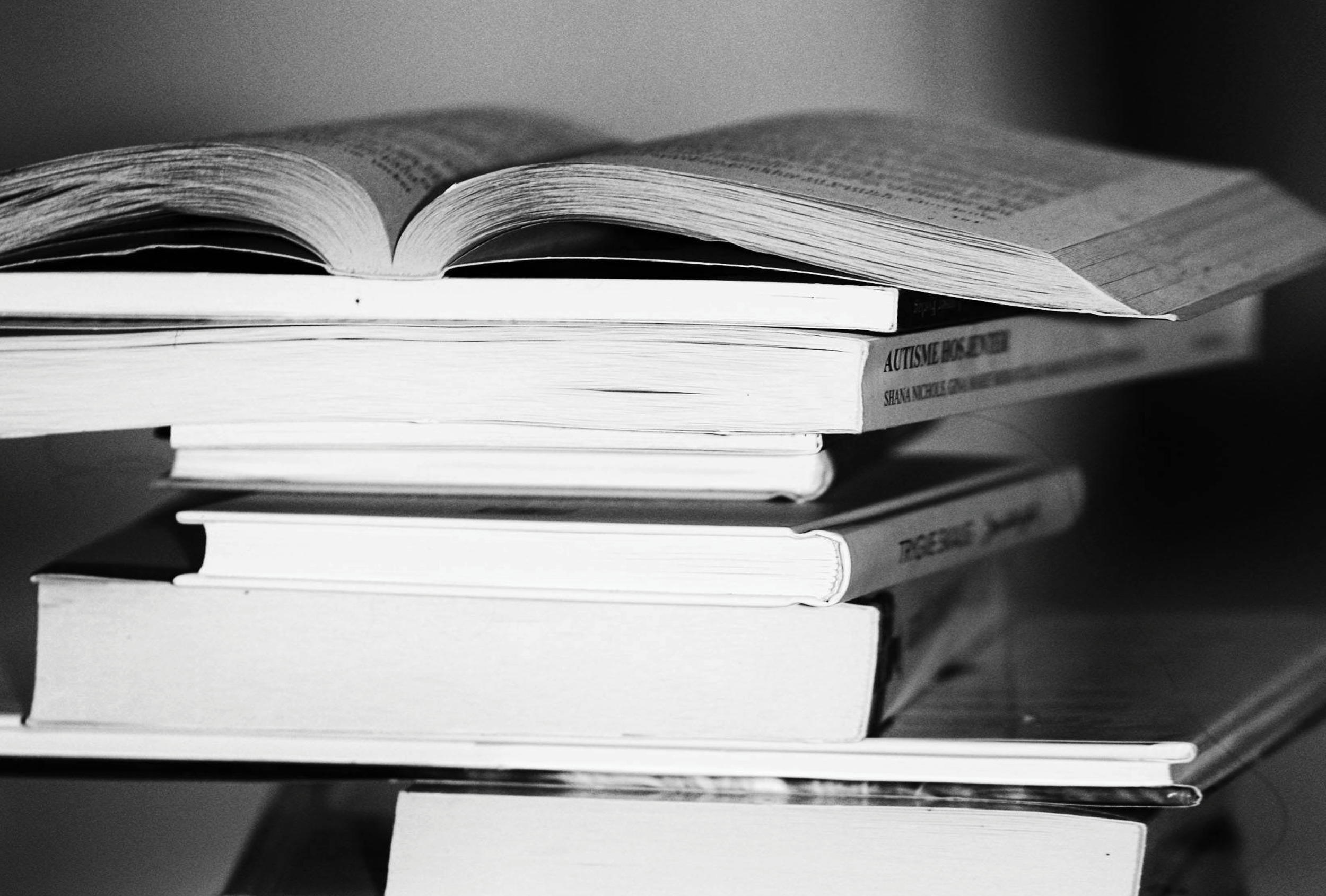 Stack of books with an open book on top, black and white photograph