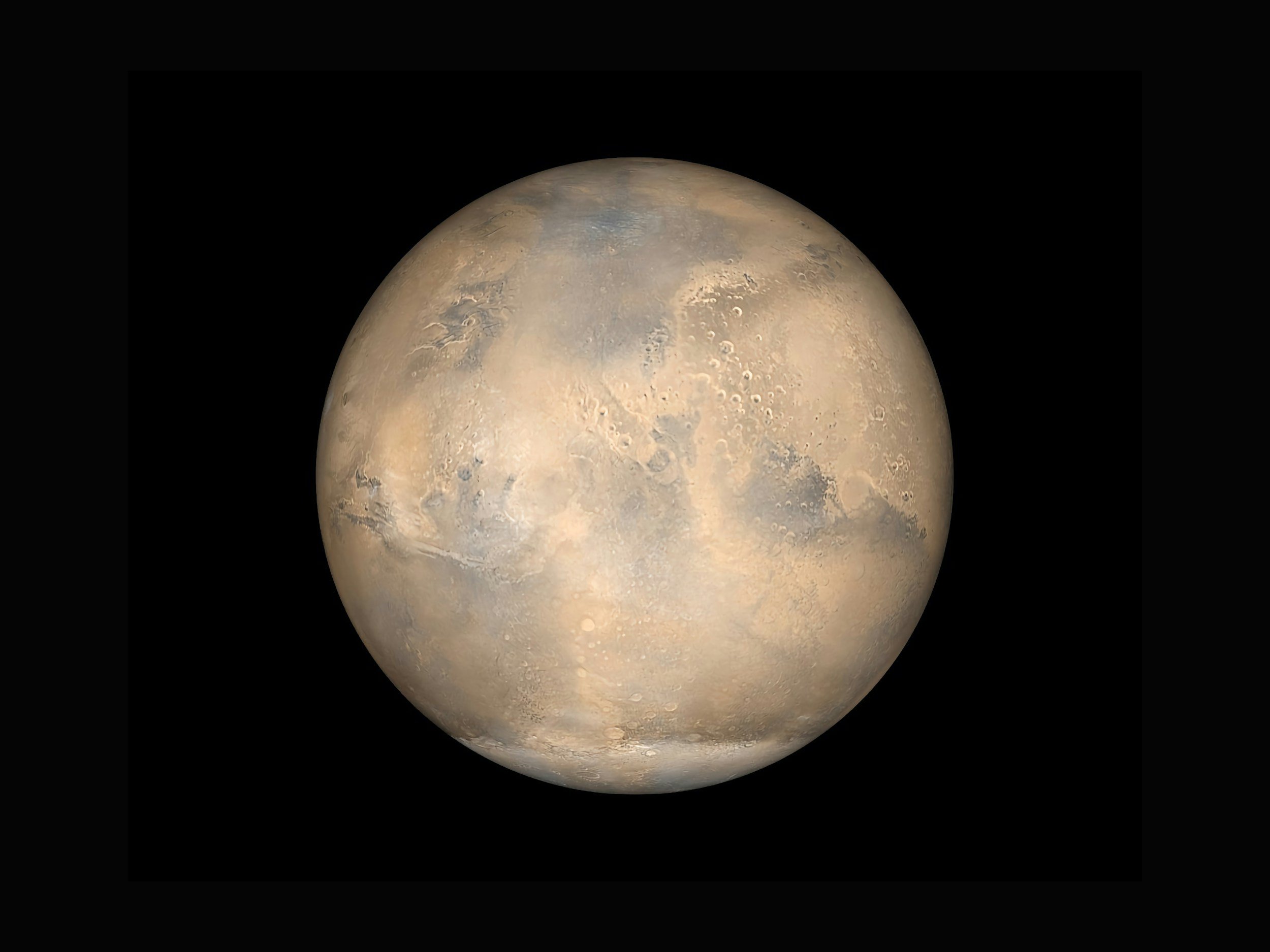 Close-up image of the planet Mars showing its surface with craters, plains, and color variations against a black background.