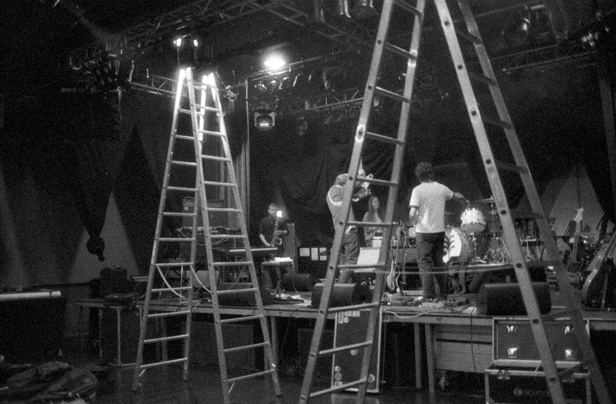 Stage setup with ladders and lighting equipment before soundcheck.