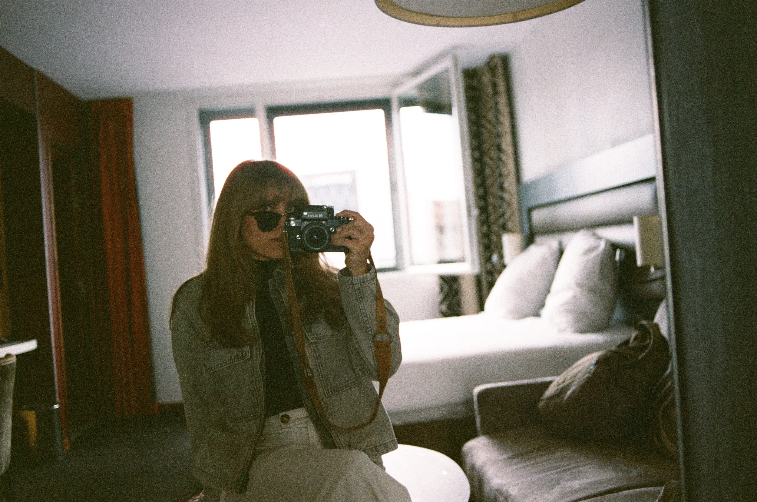 Self-portrait reflected in mirror, hotel room