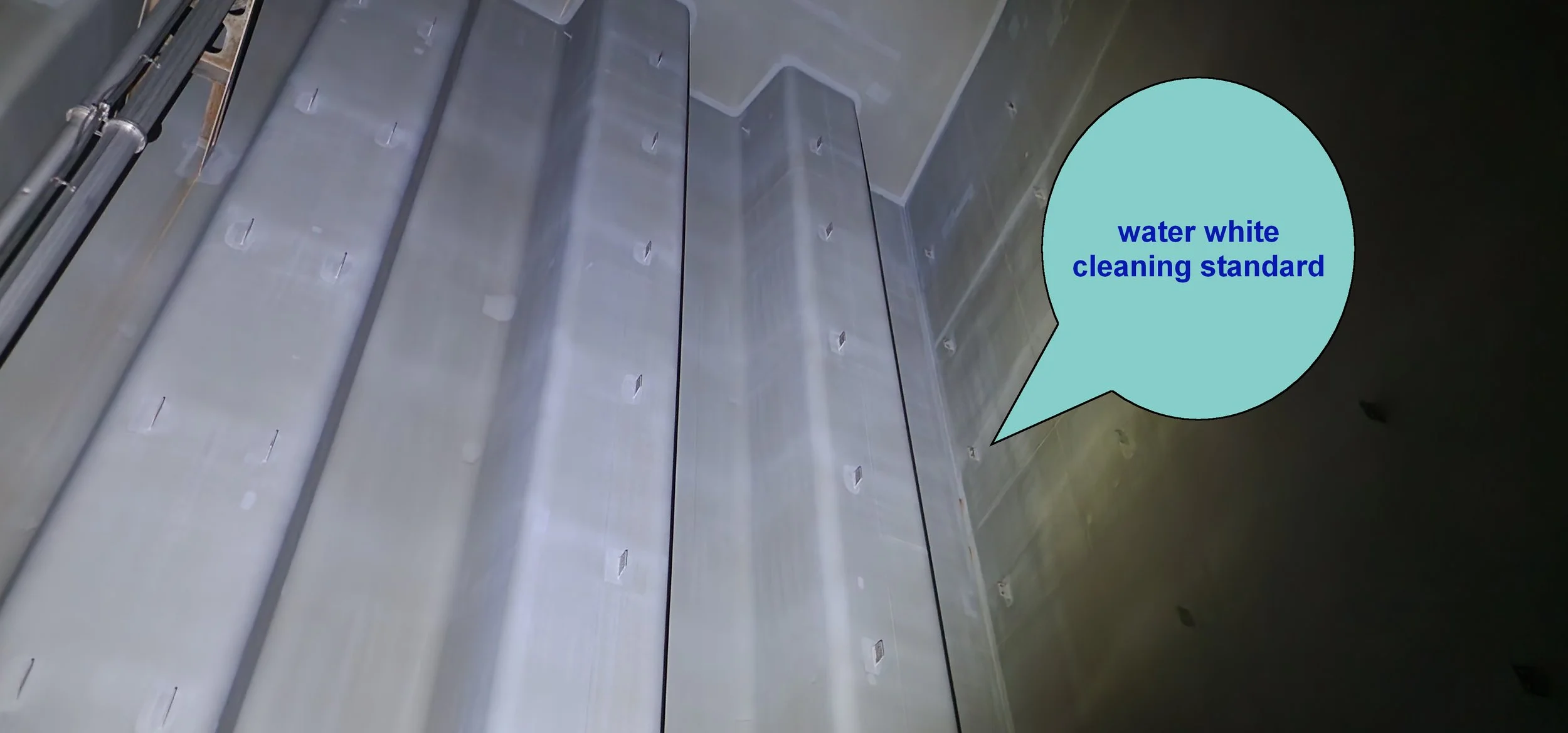 Close-up of metallic electrical panels or enclosures with a speech bubble pointing to them, labeled "water white cleaning standard" in blue text.