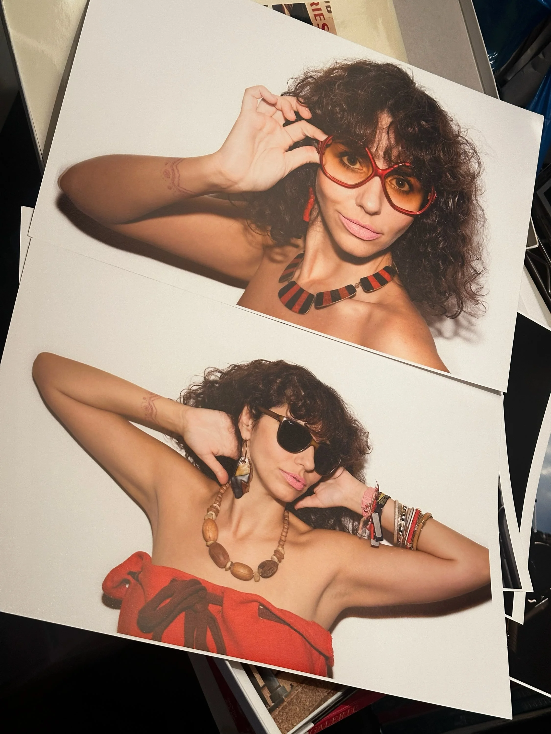 Photographs of Renata Abbade by Paul Park - a woman with curly dark hair, wearing sunglasses and colorful accessories, posing against a plain white background.