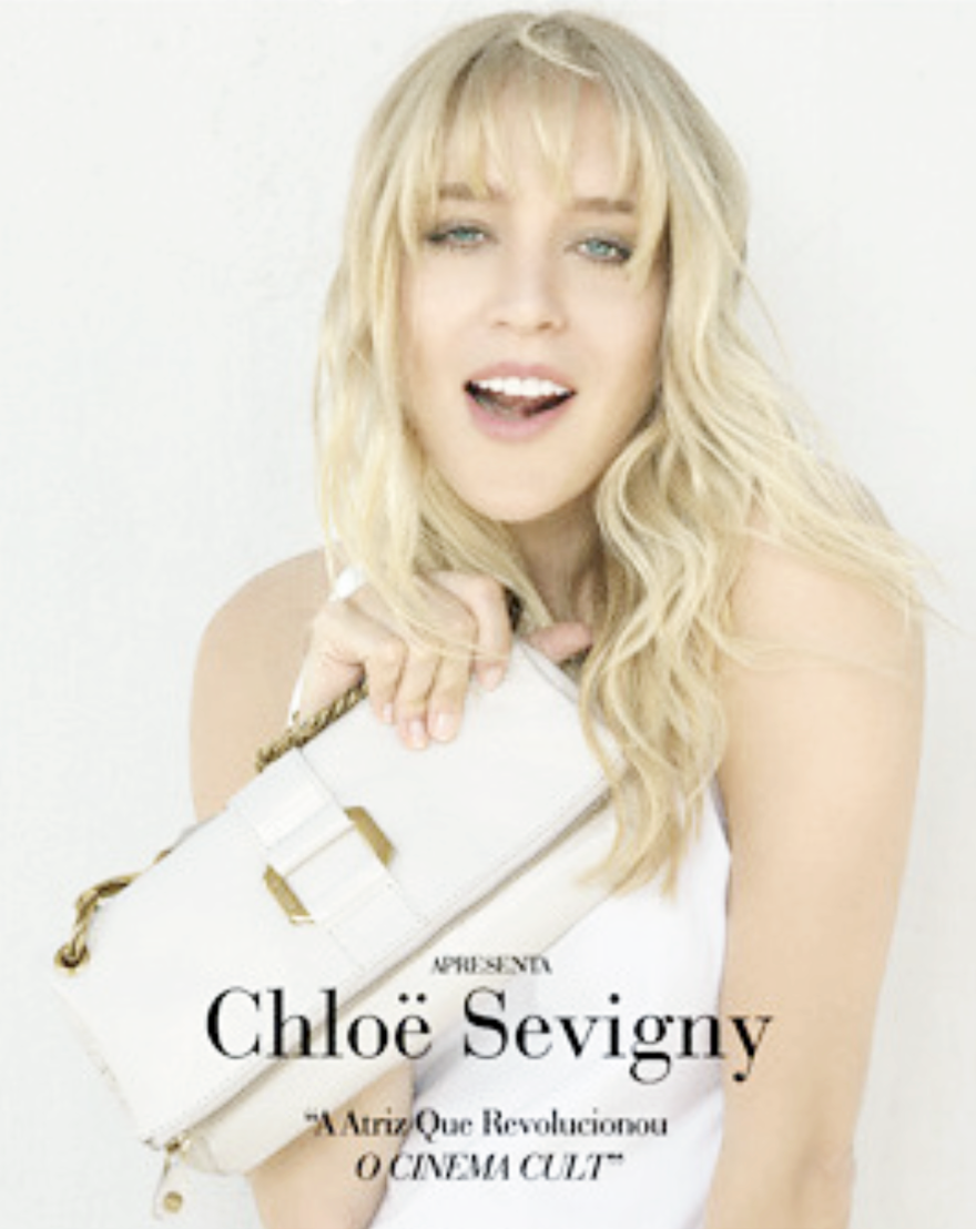 Close-up of Chloe Sevigny shot by Marcelo Krasilcic, an actress holding a white purse, smiling and looking at the camera.