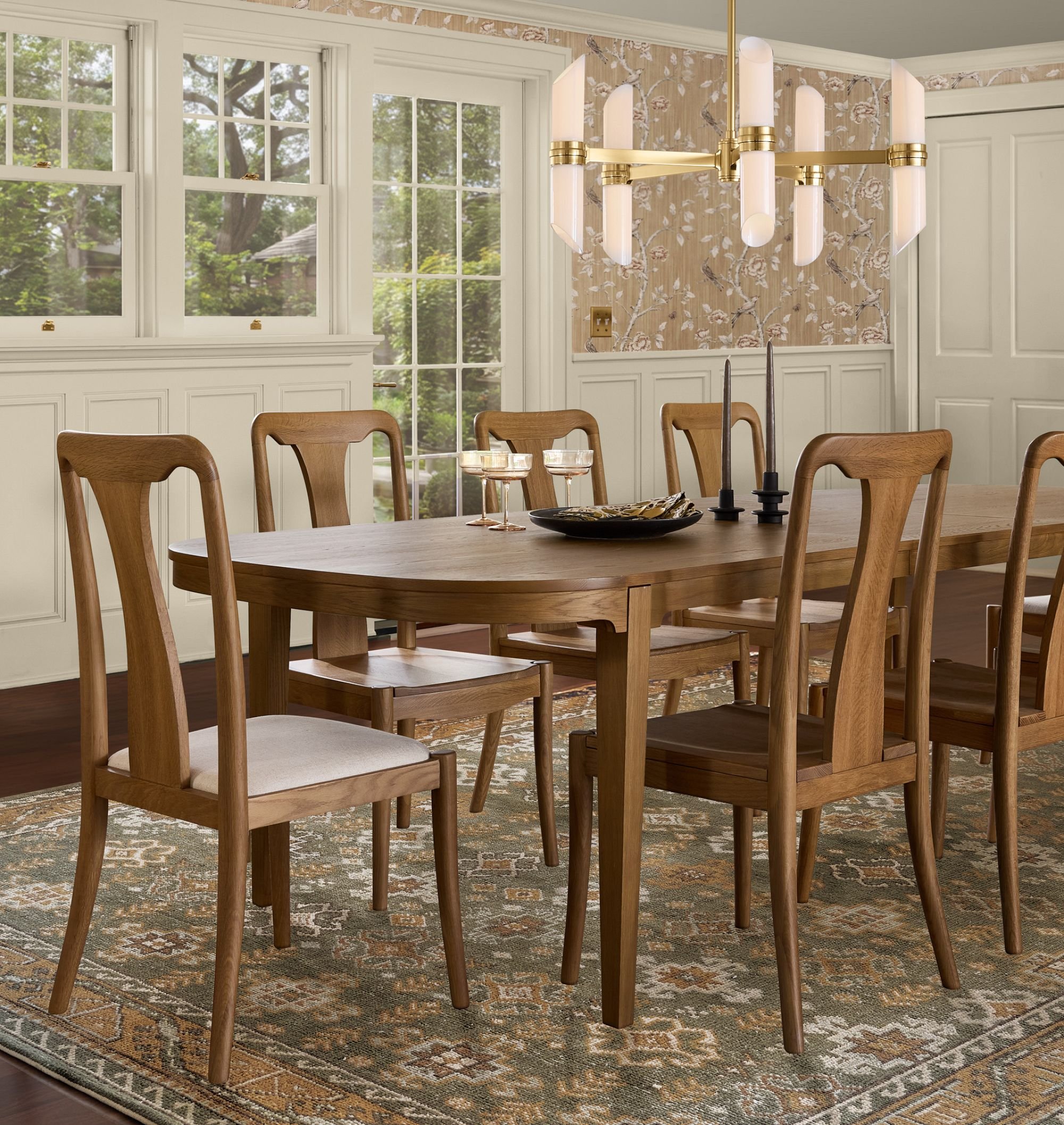 transitional dining room table and chairs with green area  rug and contemporary chandelier