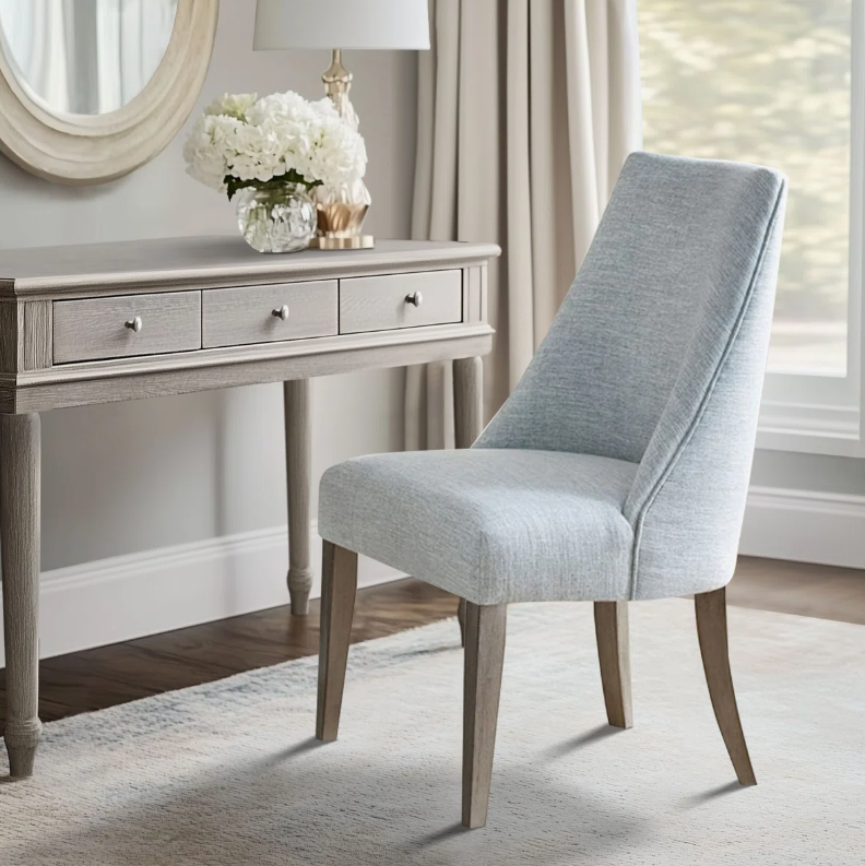 Transitional dining chair featuring light blue upholstery, tapered wood legs, and a streamlined upholstered design.