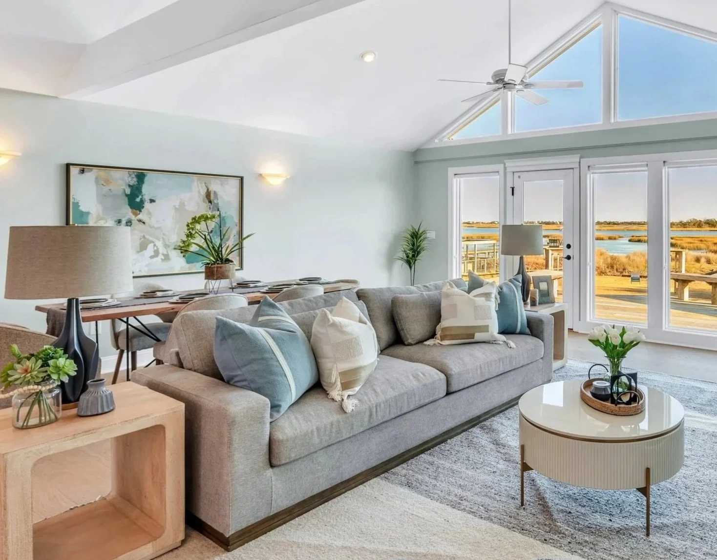 Modern coastal living room with soft blue upholstery, white walls and ocean views