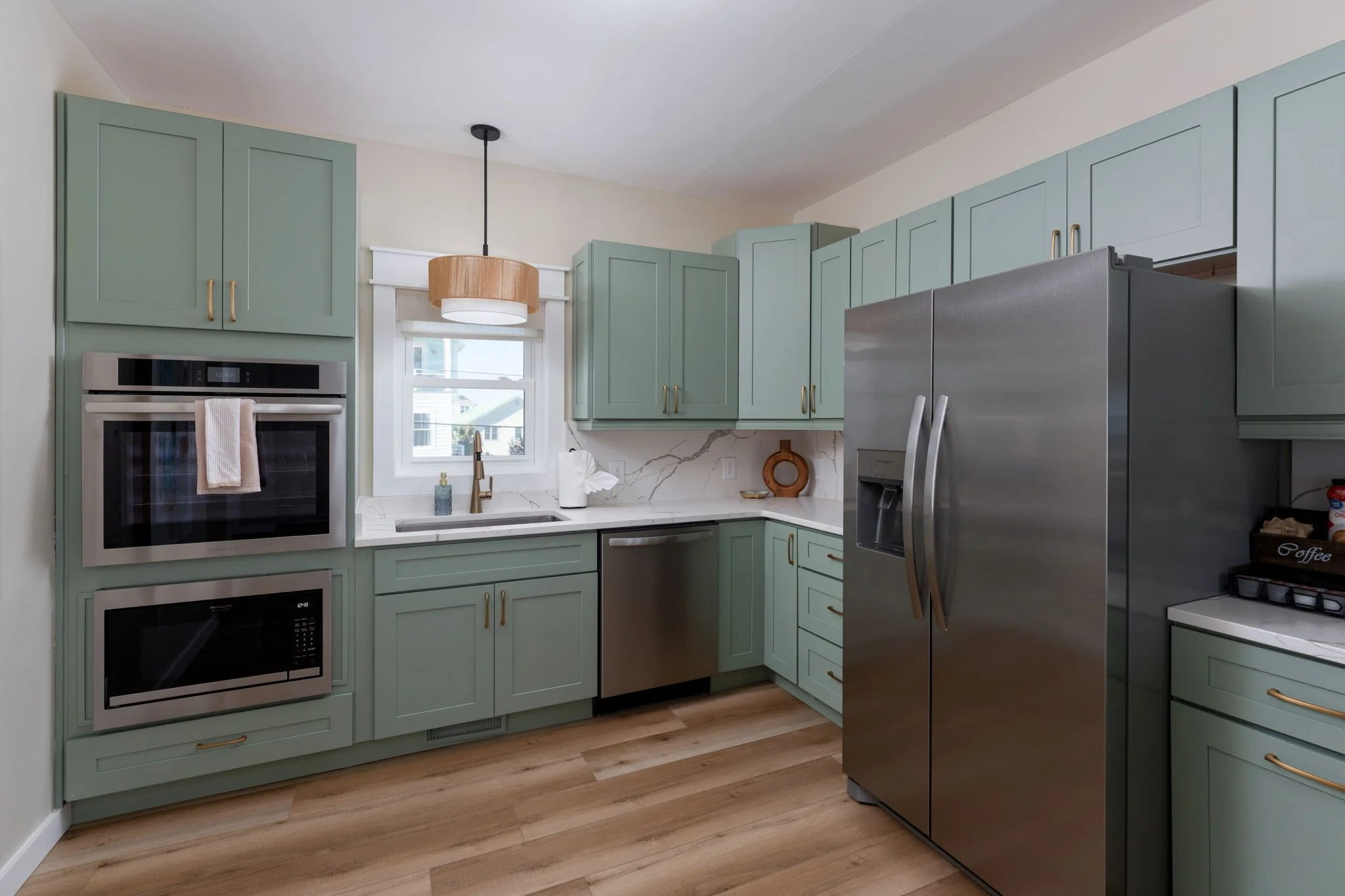 rental-property-designer-pale-green-cabinets-marble-counters-backsplash.jpg