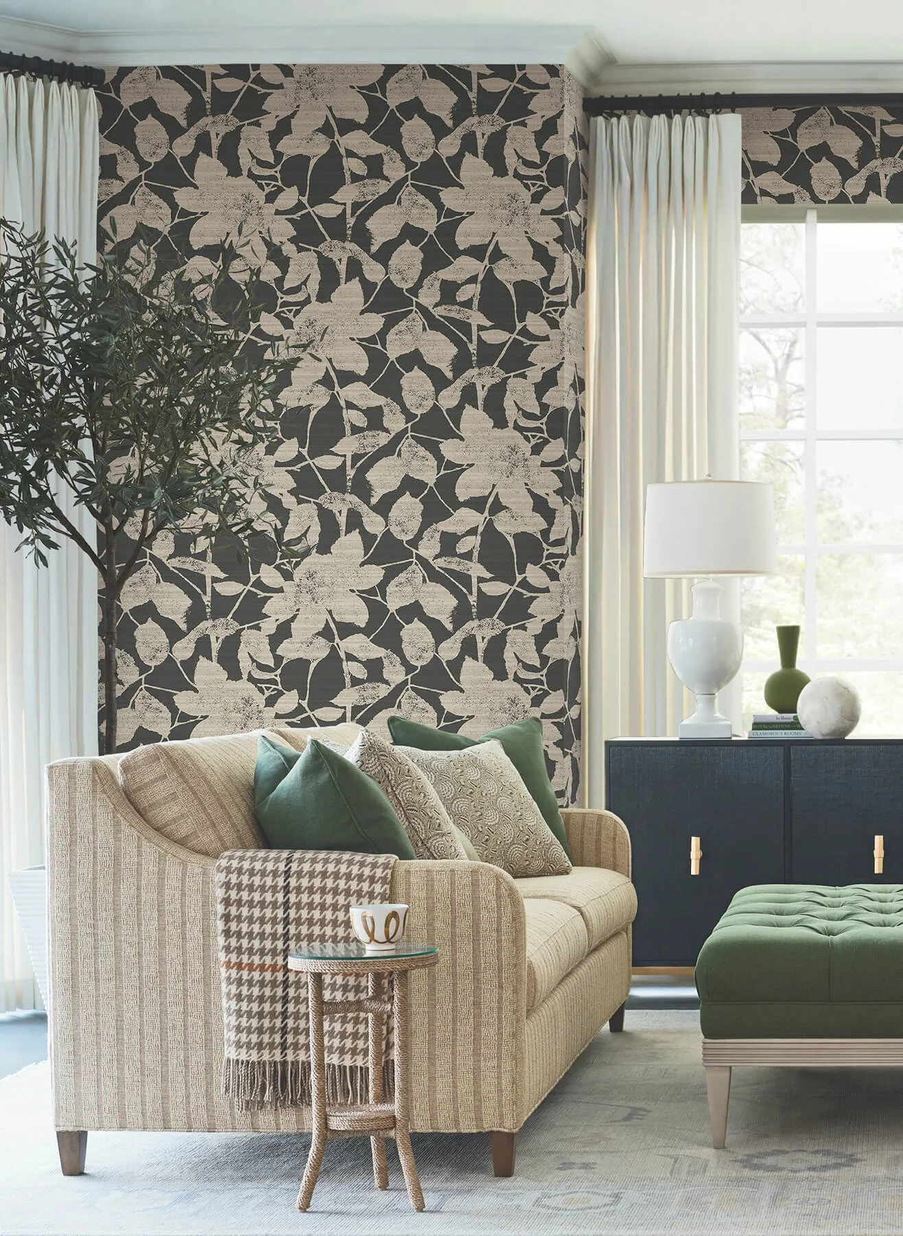 Transitional living room with a bold patterned accent wall, neutral seating, warm wood furniture and layered textures.