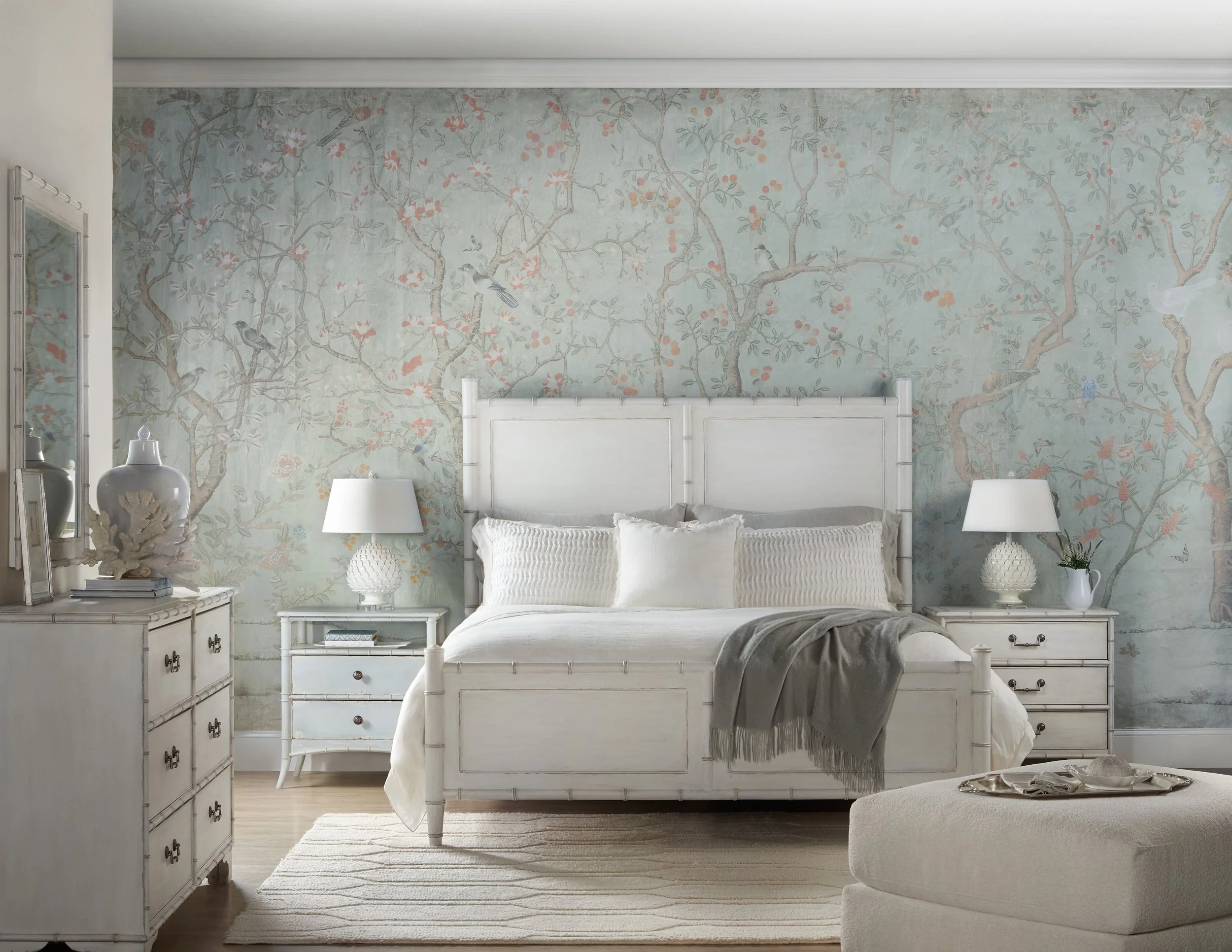 Traditional coastal bedroom image. White cane bed with matching nighstands and pale blue wallpaper.