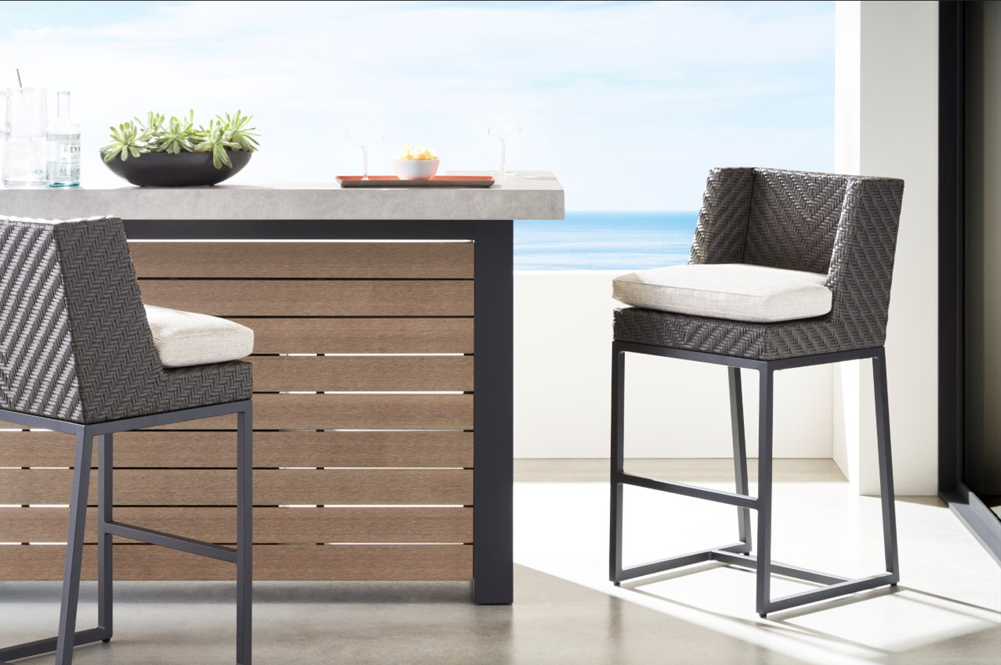 Outdoor bar with bar seating connected to an outdoor kitchen and dining area, creating a functional outdoor living space for entertaining.