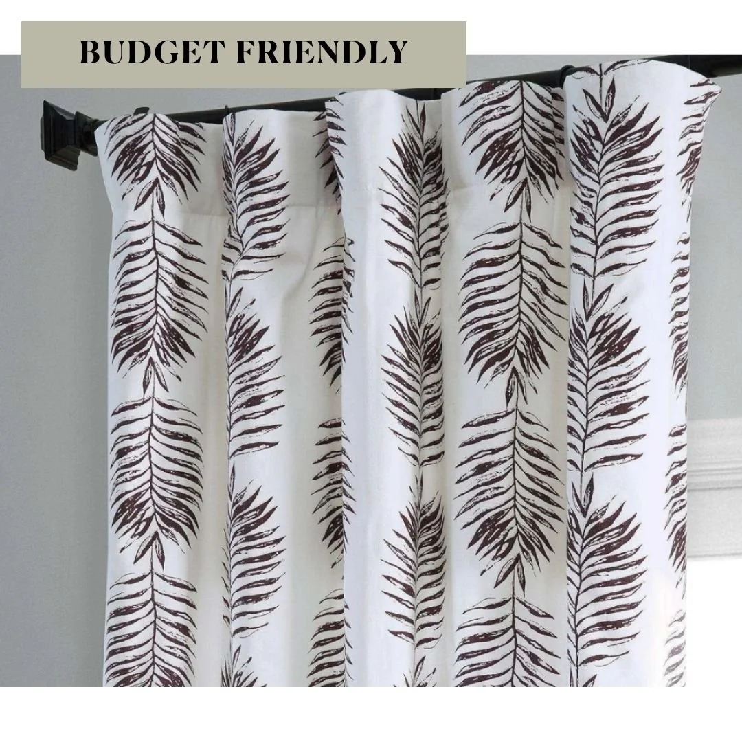 White curtain panels featuring a dark brown botanical leaf print, a stylish patterned window treatment.