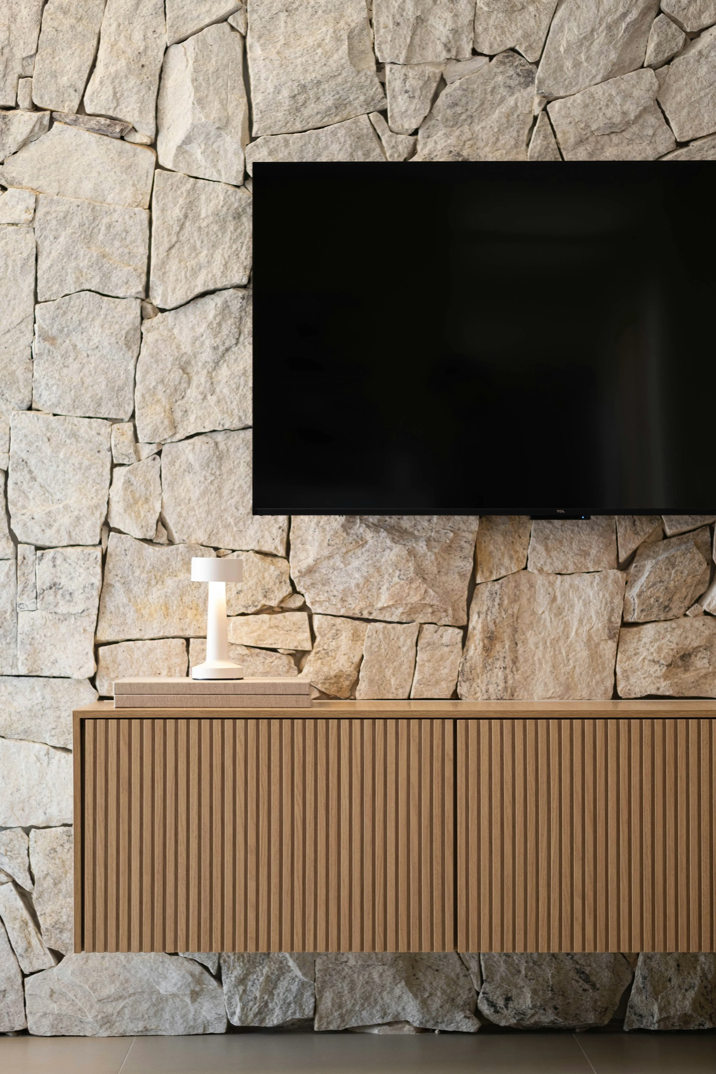 Textured natural stone accent wall surrounding a living room