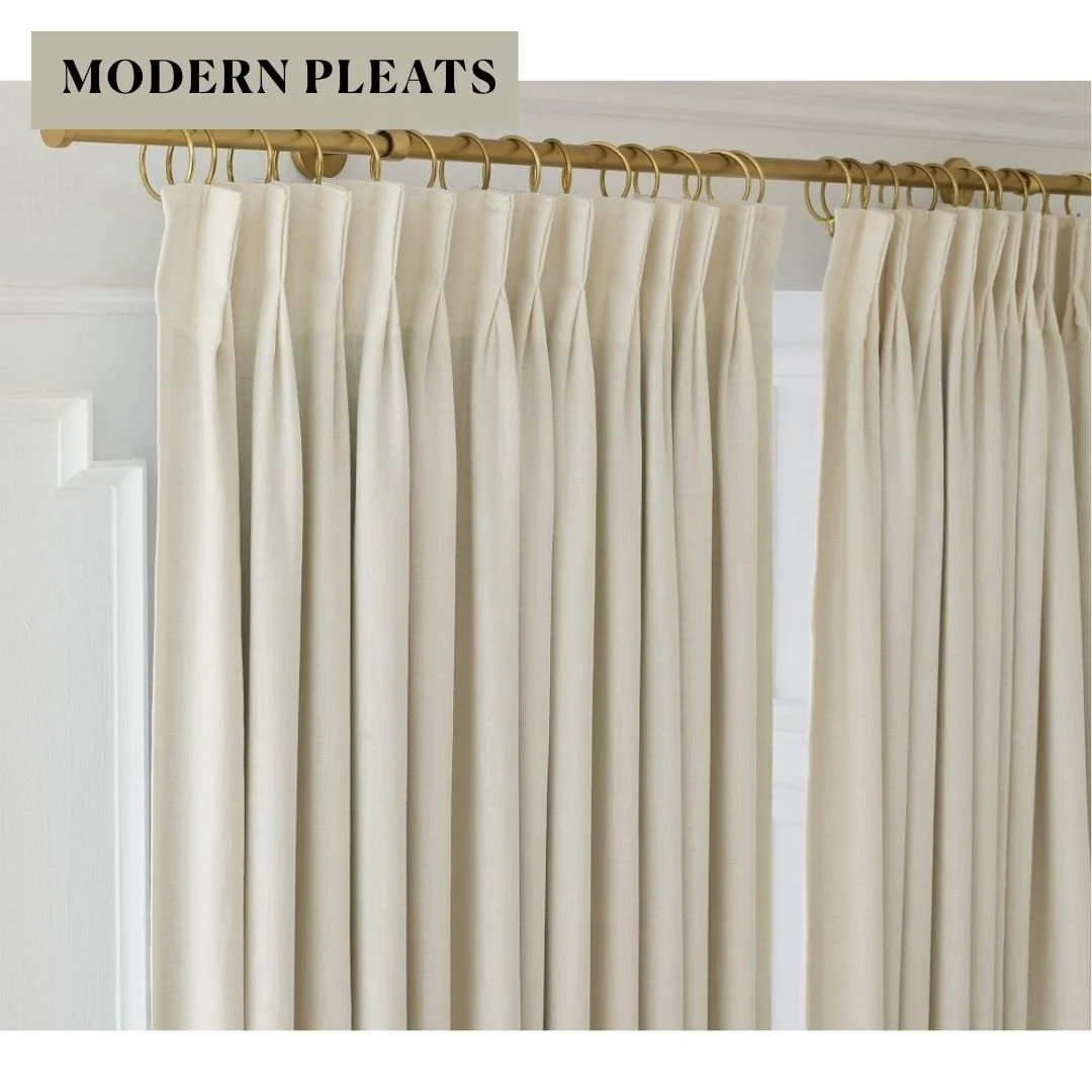Ivory European flax linen curtains with tailored pleats hanging from a brass curtain rod with rings.