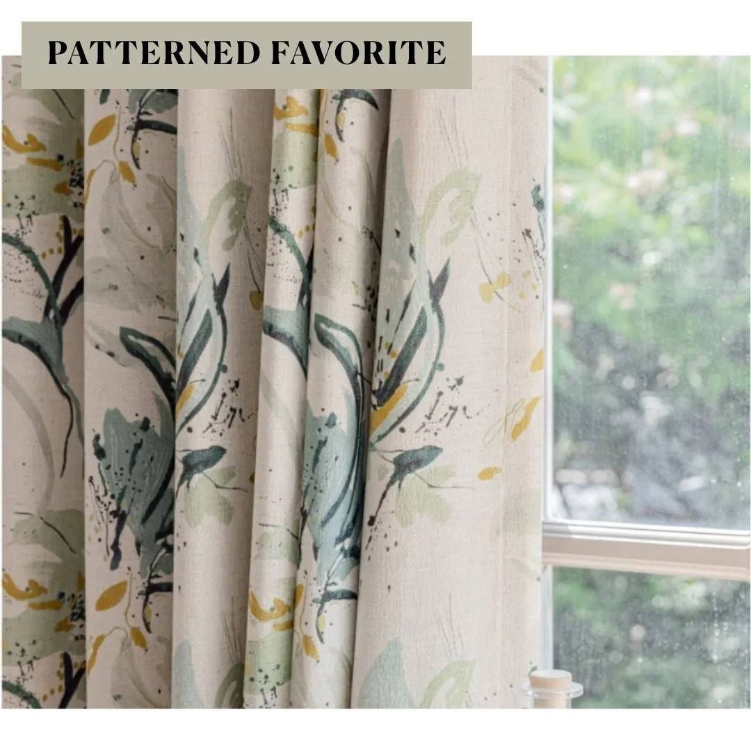 Floral curtain panels with soft blue, green, and yellow botanical patterns hanging beside a window.