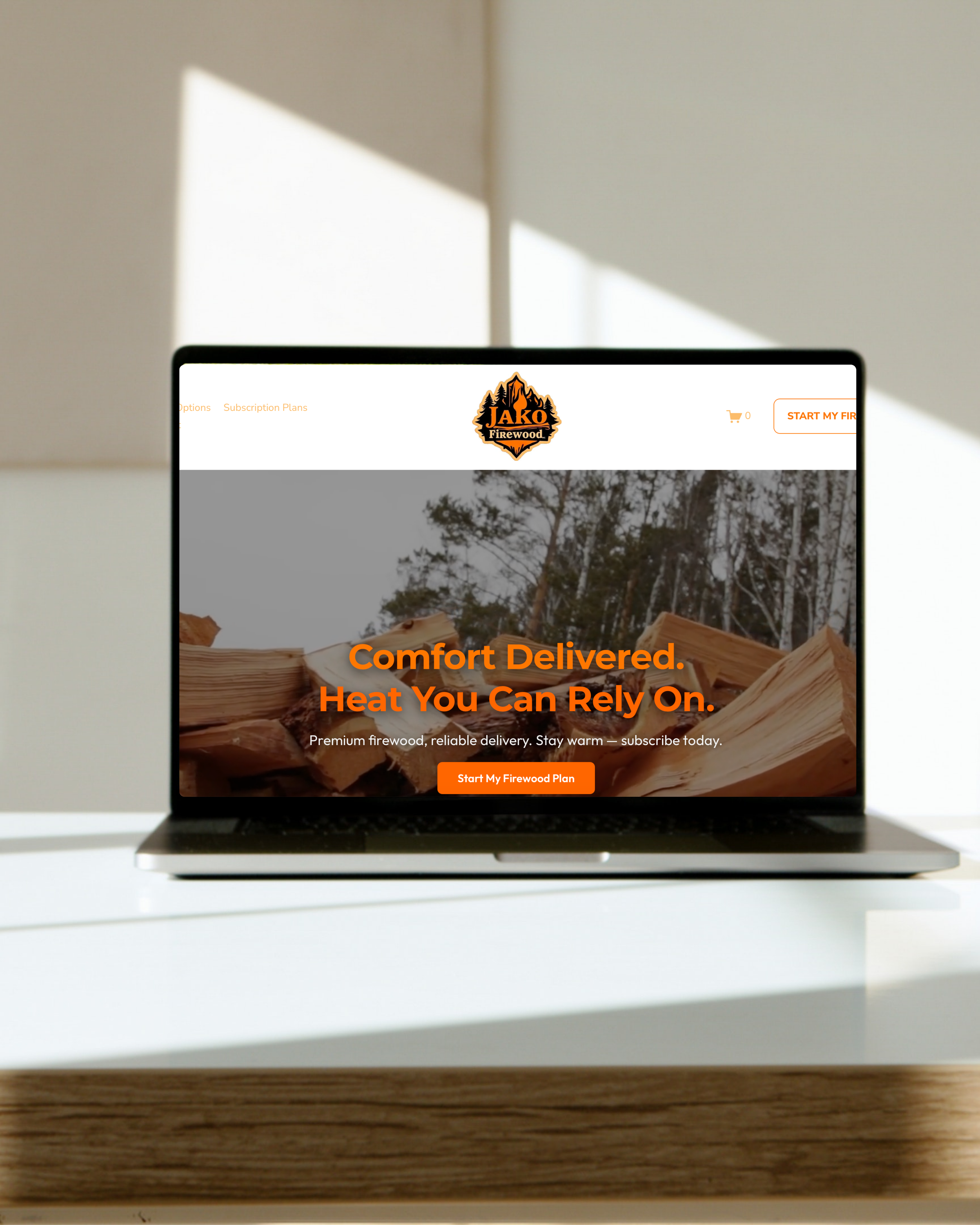 Laptop displaying a firewood delivery website with a background of stacked firewood and trees. This is an example of Gold Coast Digital's work.