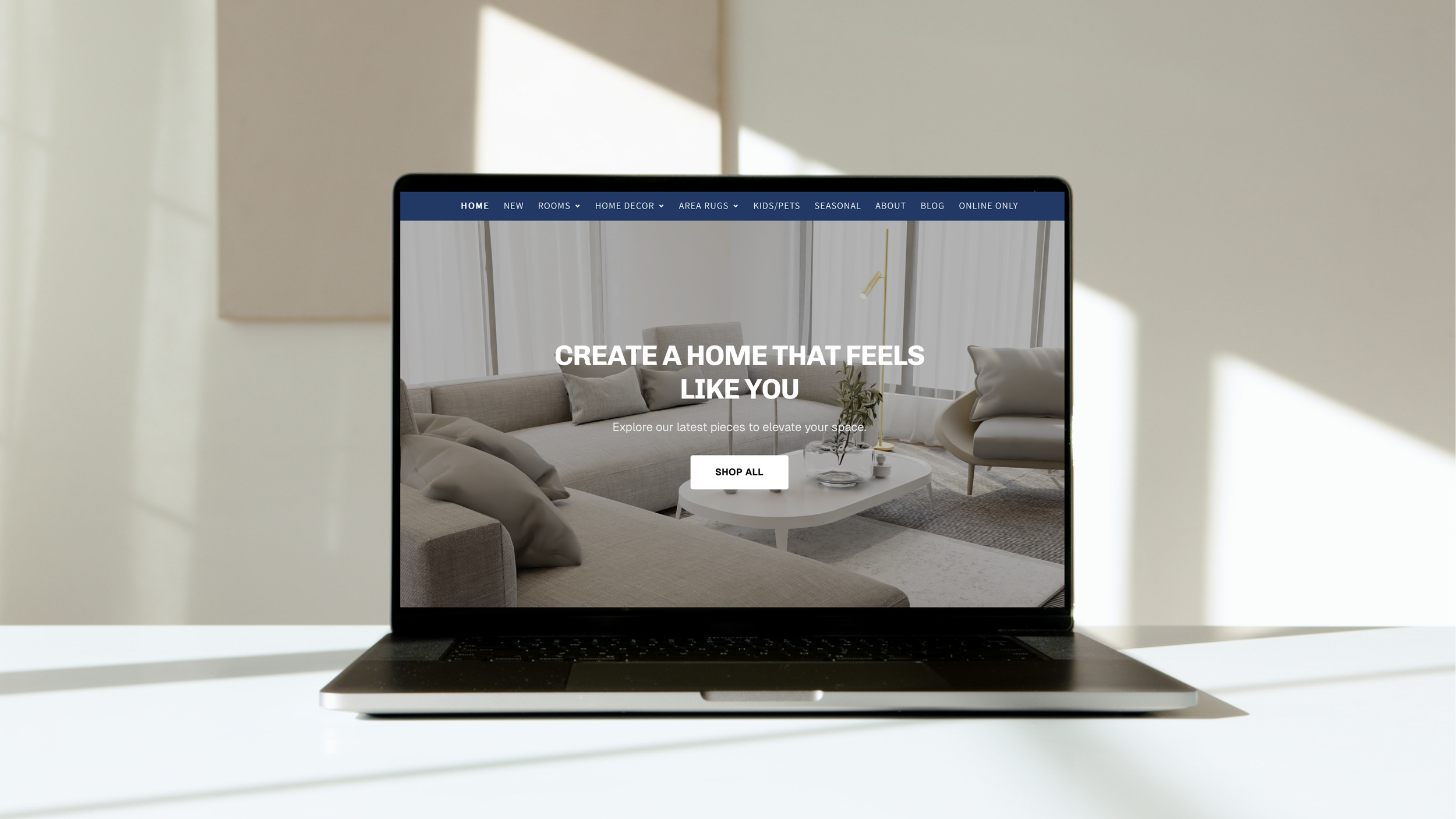 Laptop displaying a home decor website with a modern living room featuring neutral furniture, a coffee table, and large windows with curtains.