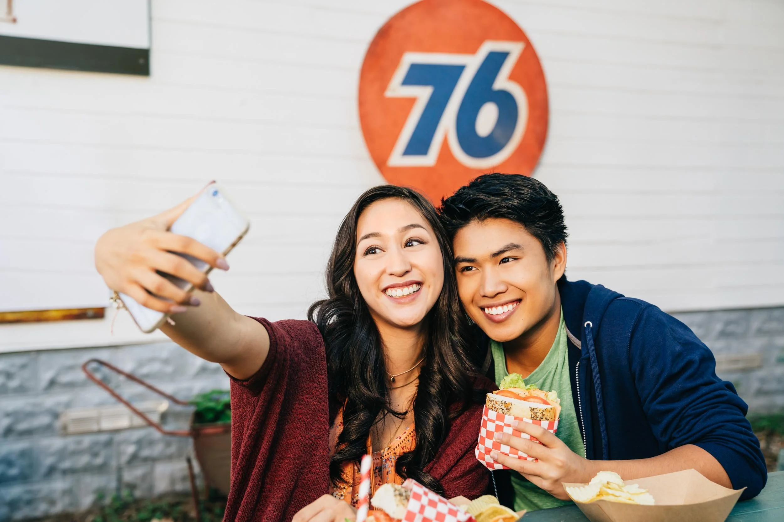 Happy-couple-eating-at-outside-cafe-taking-selfie.jpg
