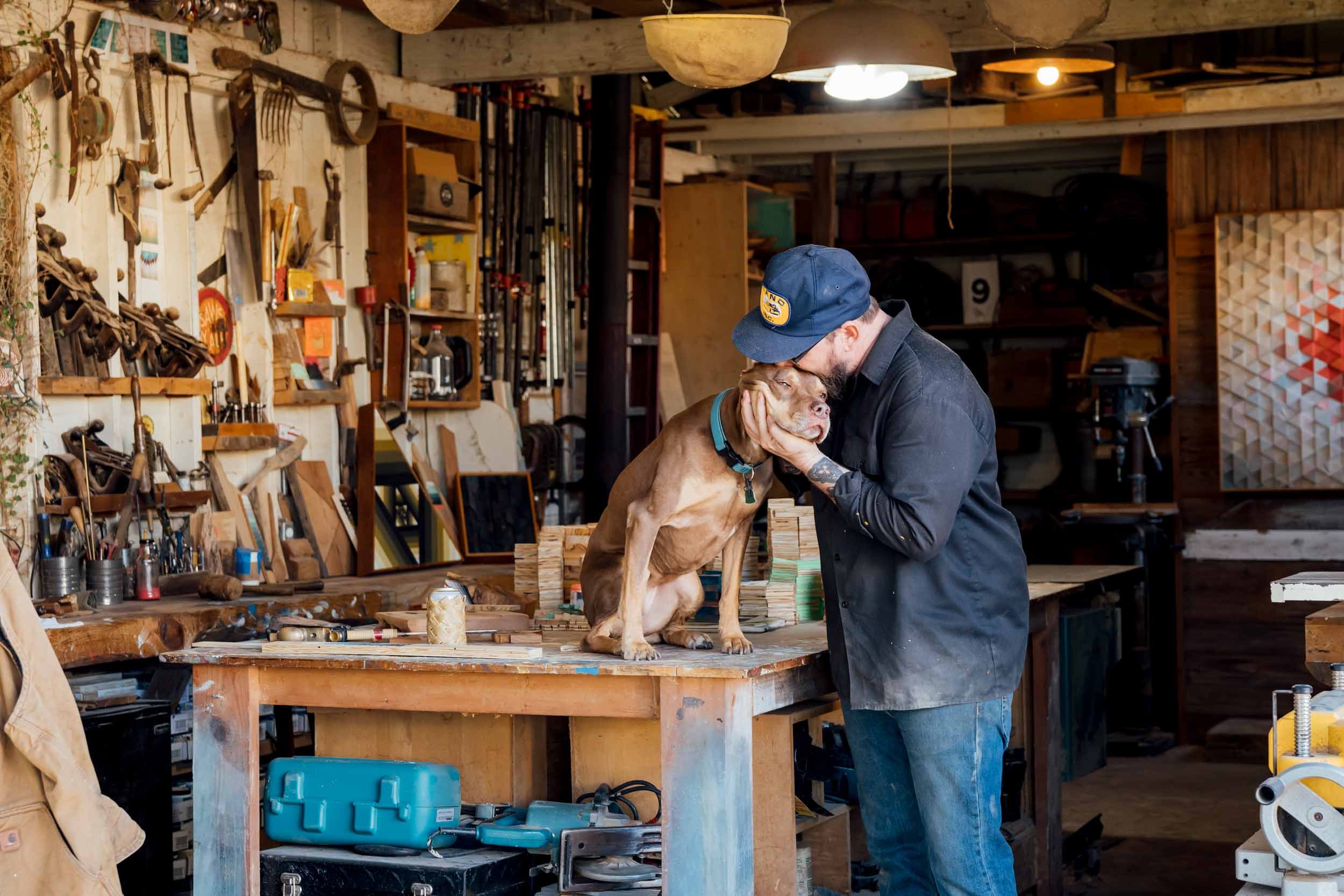 Man-Hugging-Dog-in-Workshop.jpg