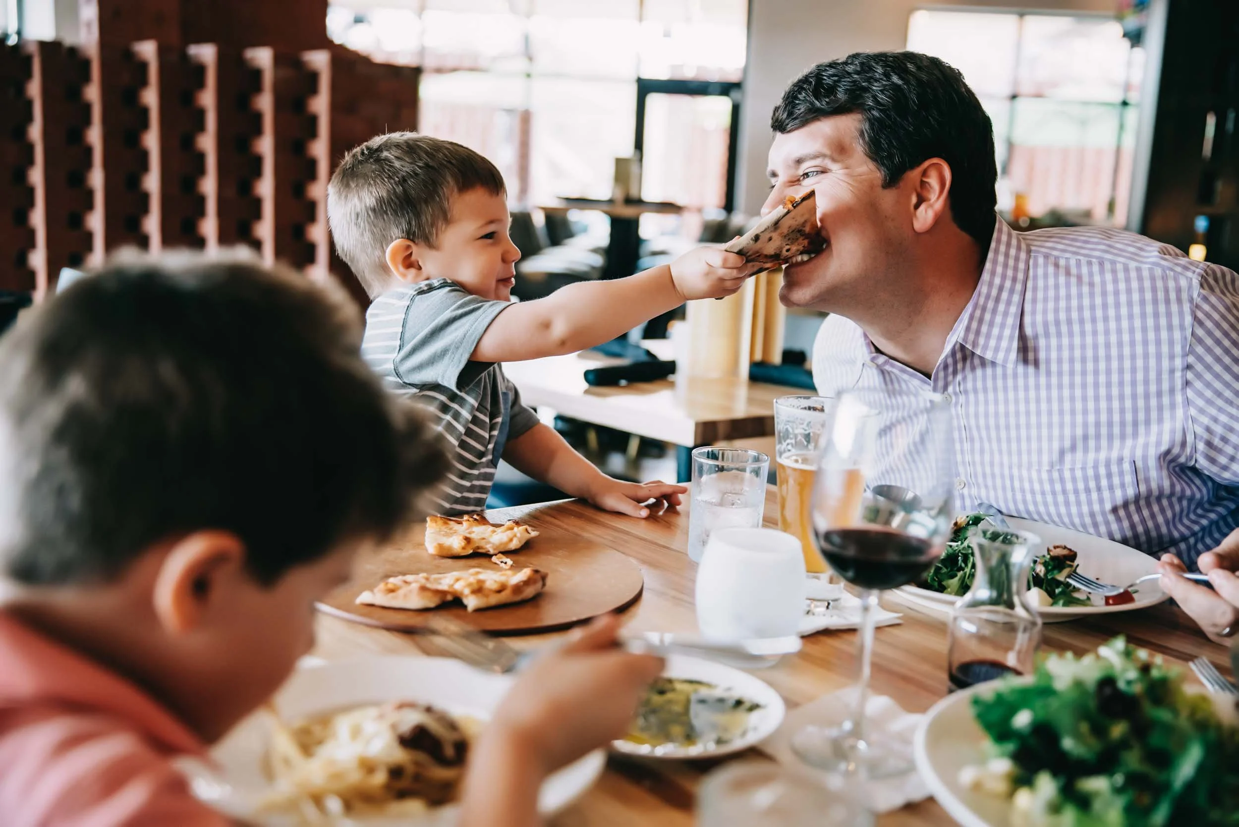 Boy-feeding-dad-pizza-in-restaurant.jpg